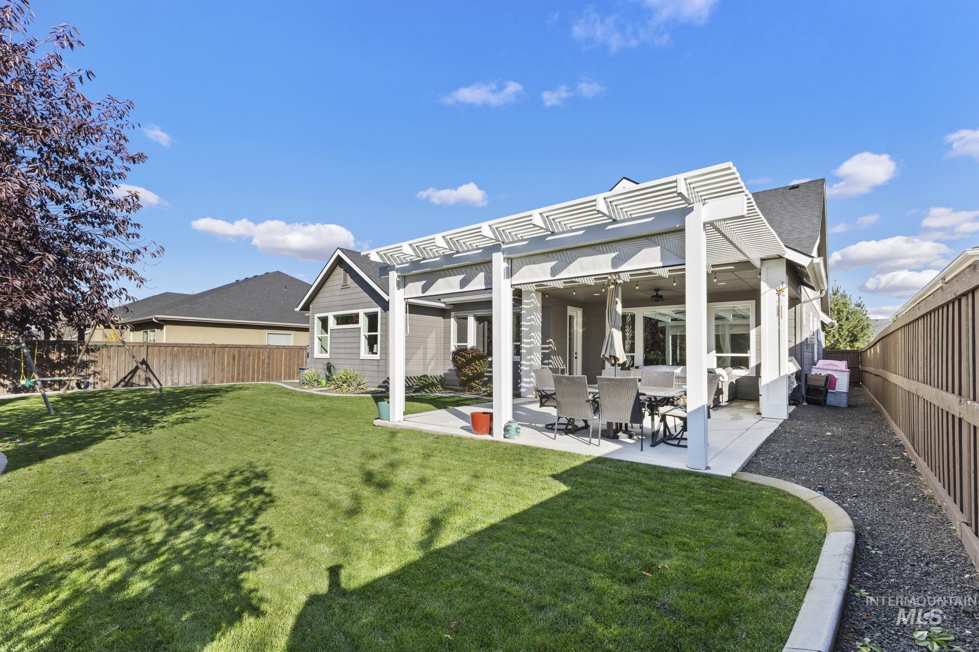 Rear view of property featuring a fenced backyard, a patio area, a ceiling fan, and a pergola