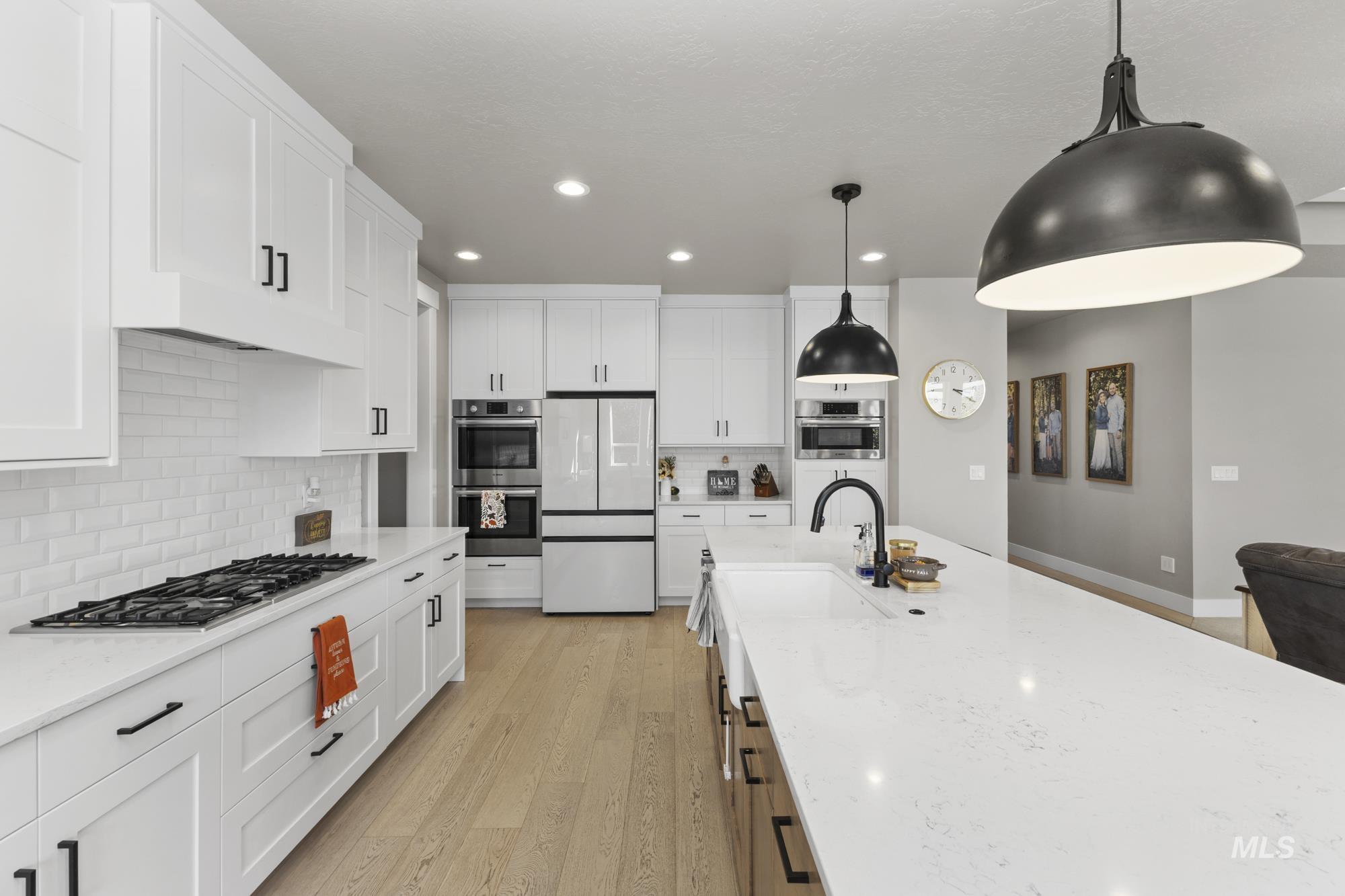 Kitchen with white cabinetry, pendant lighting, tasteful backsplash, stainless steel appliances, and recessed lighting