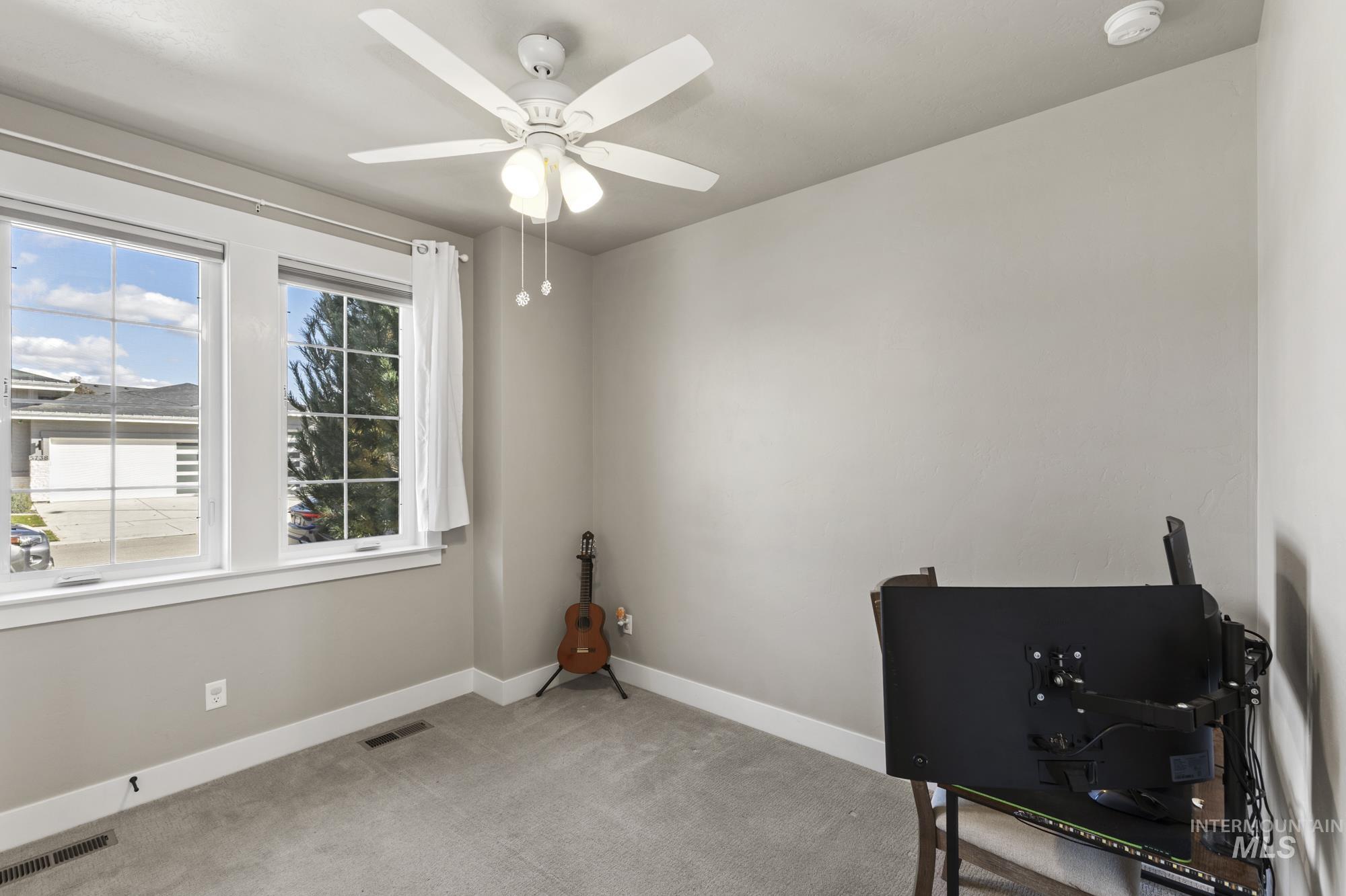 Home office featuring carpet flooring and a ceiling fan