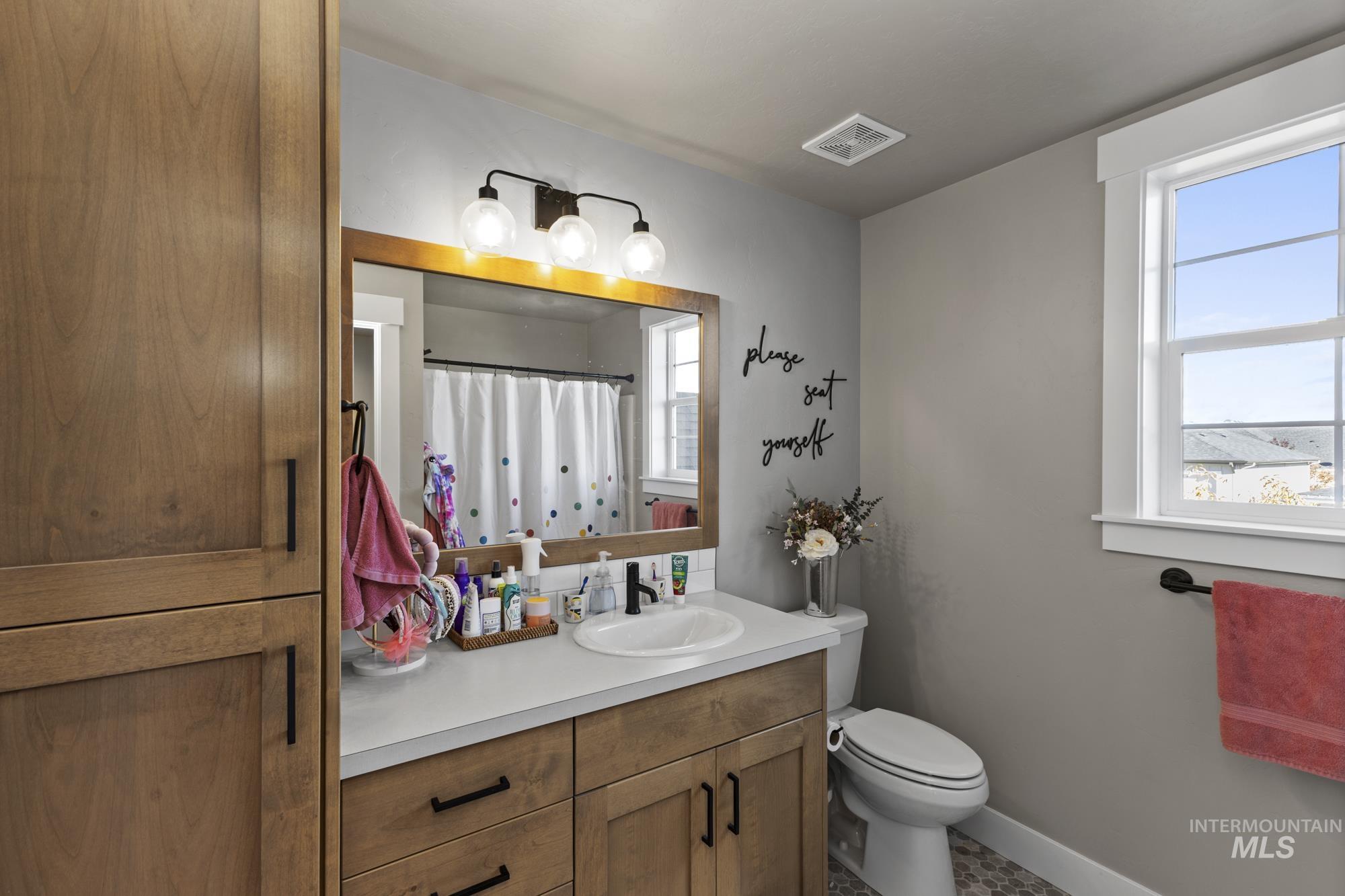 Bathroom featuring a shower with shower curtain and vanity