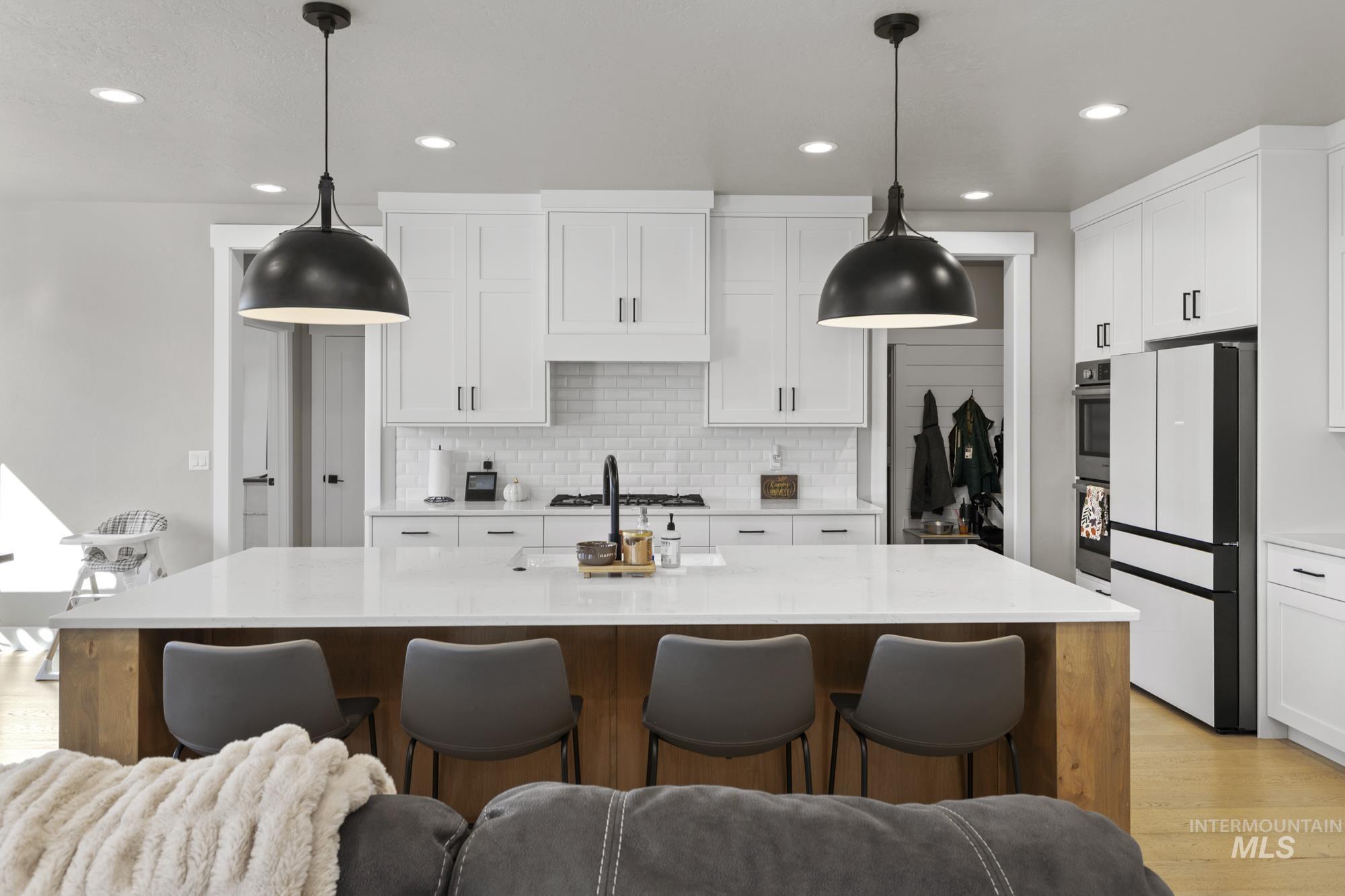 Kitchen featuring light wood finished floors, white cabinets, appliances with stainless steel finishes, and recessed lighting