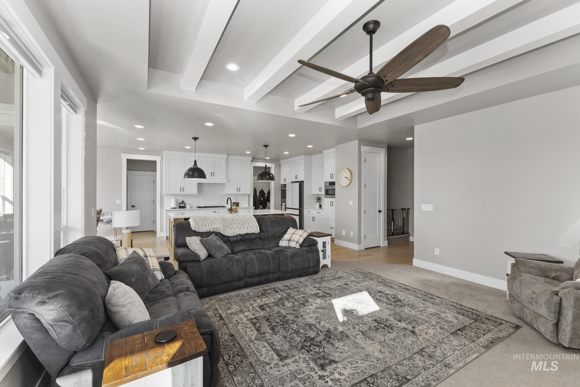 Living room featuring beam ceiling, recessed lighting, a ceiling fan, and light colored carpet