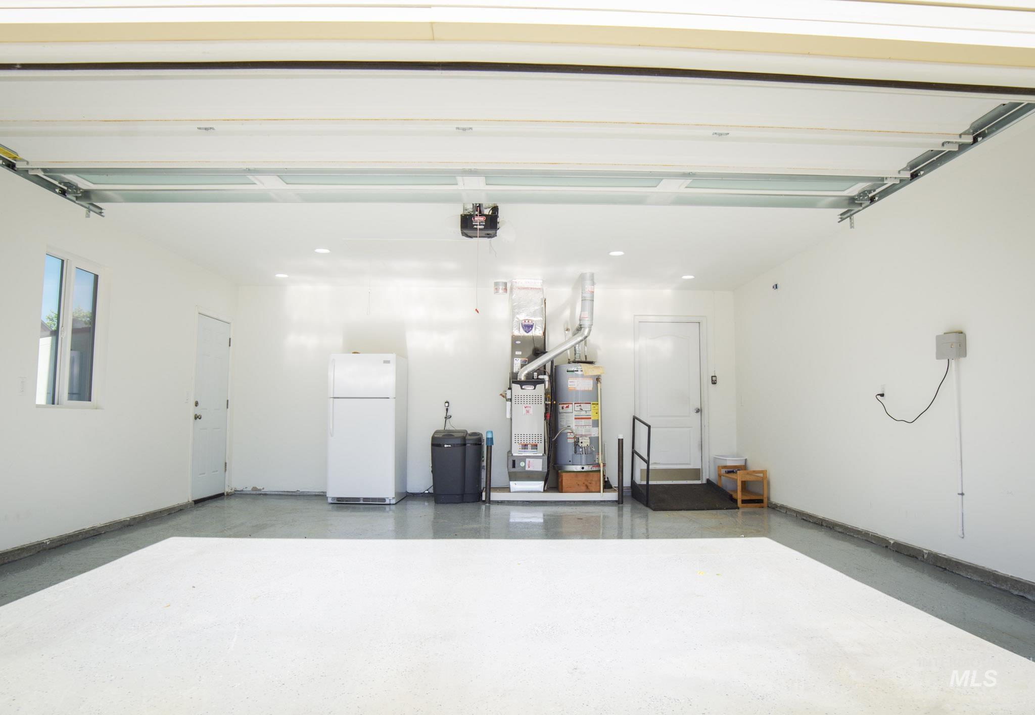 Two-car garage with white walls, a window, and an interior door