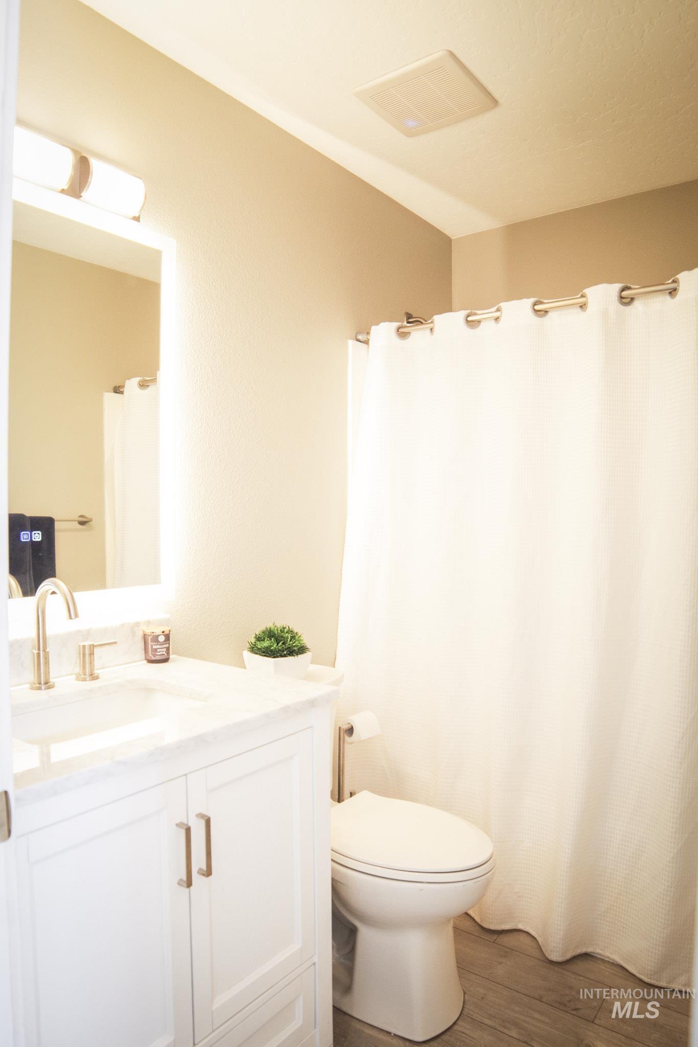 Bathroom featuring a white vanity with gold-finish hardware, a white countertop, and a brushed gold-finish faucet