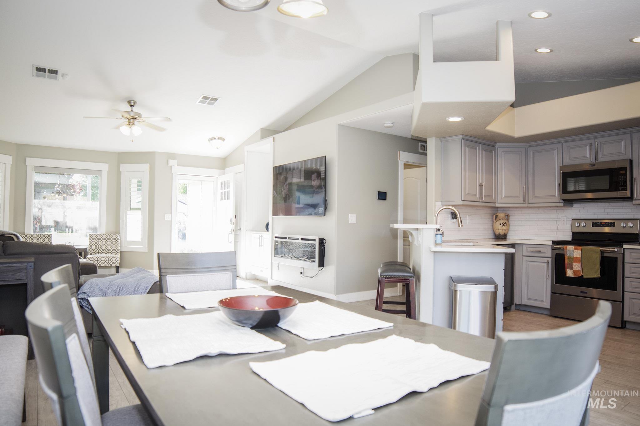 Open-concept living space featuring a dining area with wood-finish flooring
