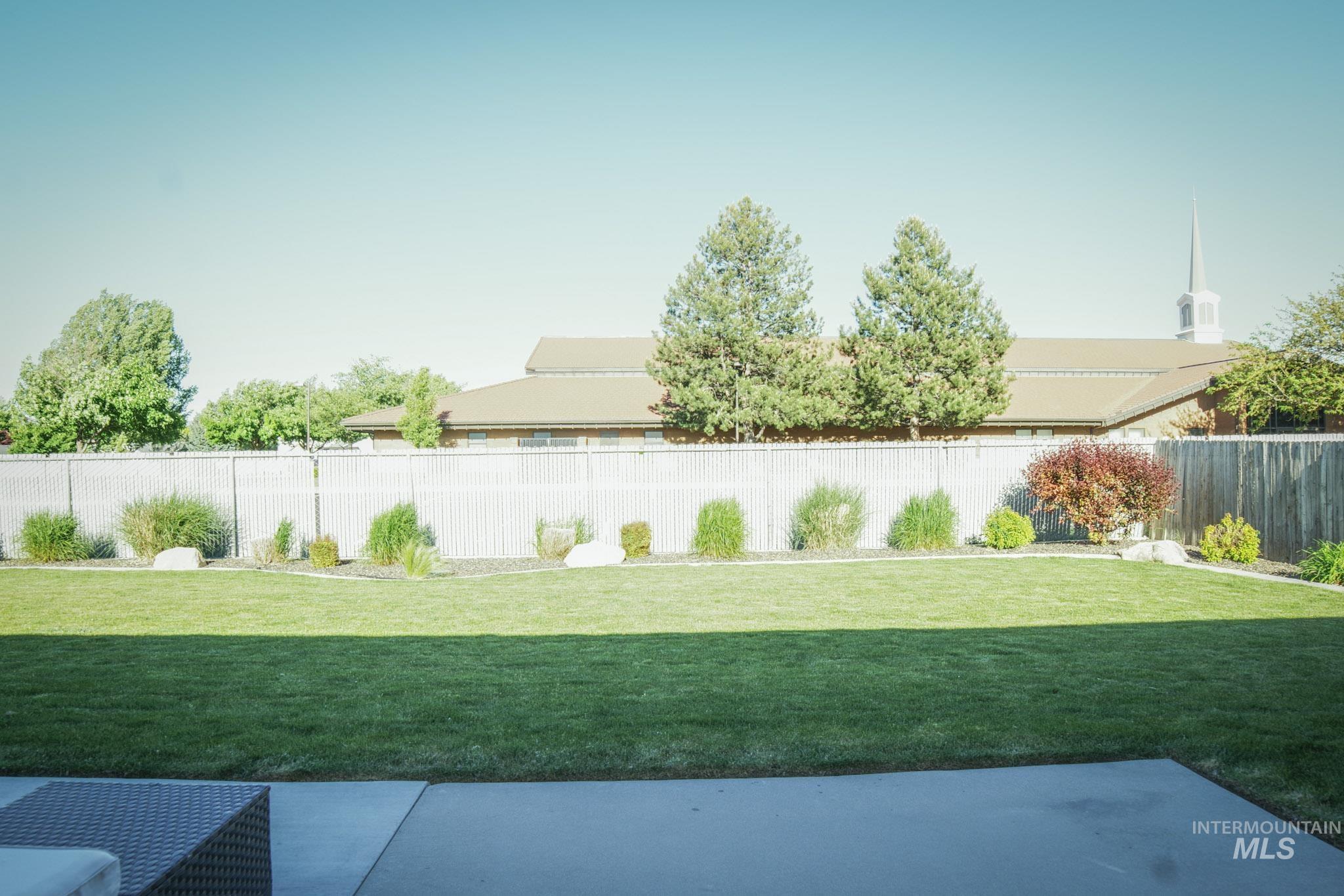 Expansive green lawn with a perimeter of mature landscaping