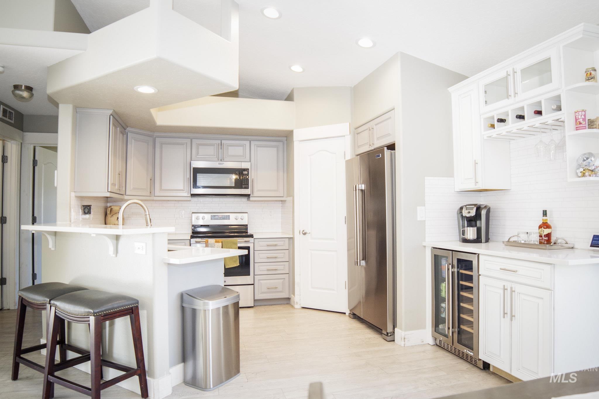Modern kitchen featuring light gray cabinetry, stainless steel appliances, and recessed lighting