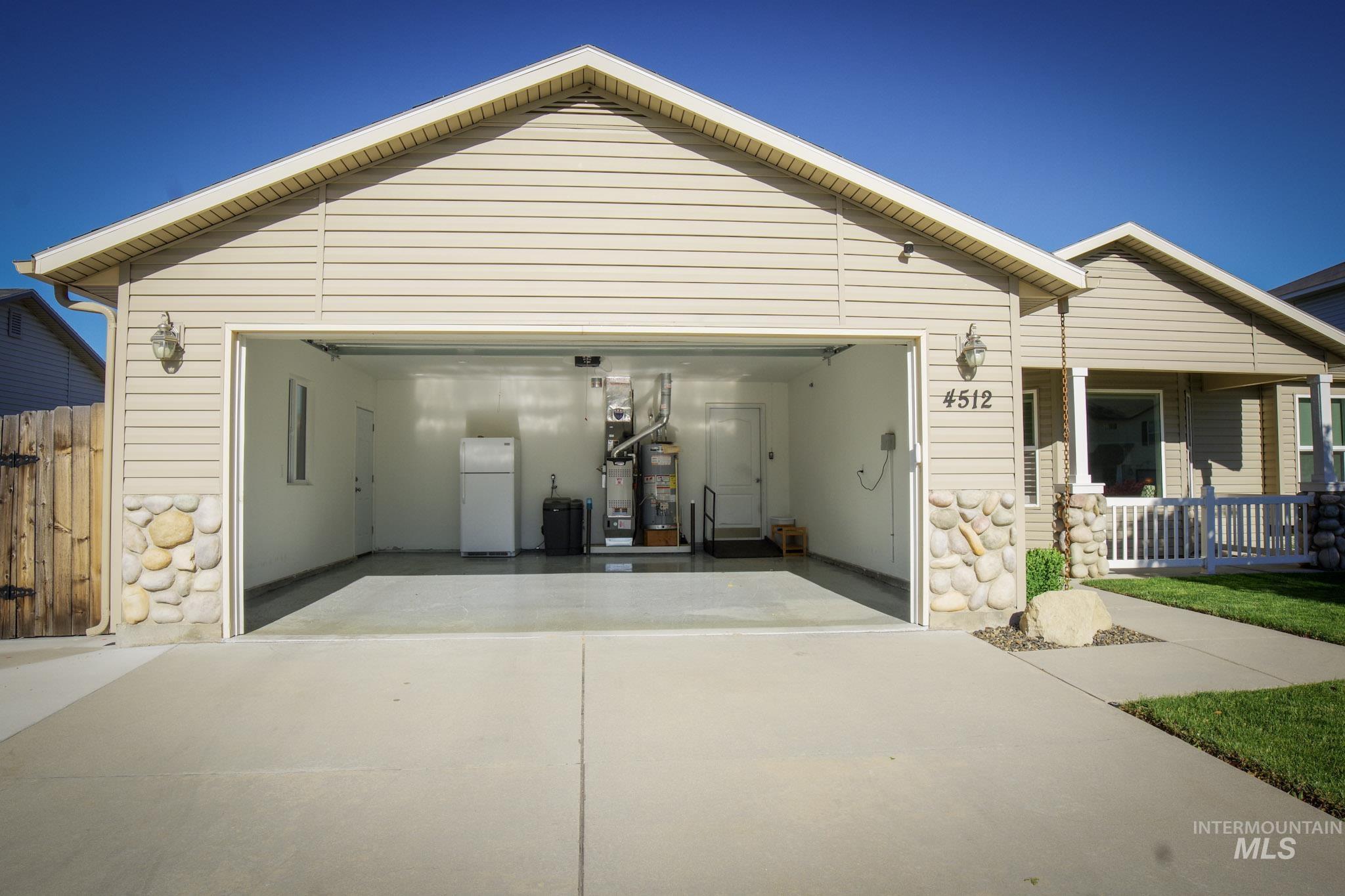 Attached two-car garage featuring a painted concrete floor