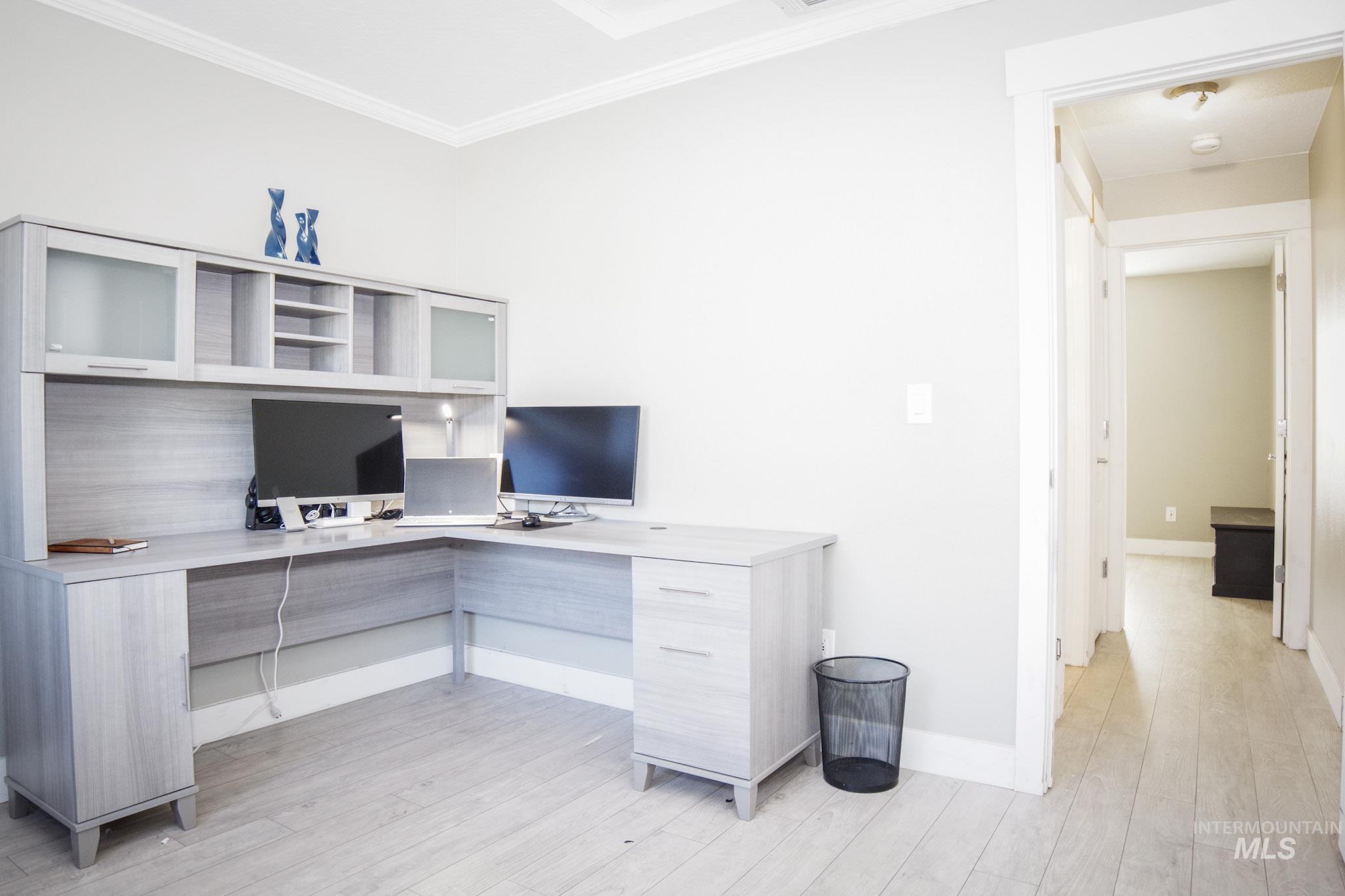 Dedicated workspace featuring a built-in L-shaped desk with integrated hutch and cabinetry