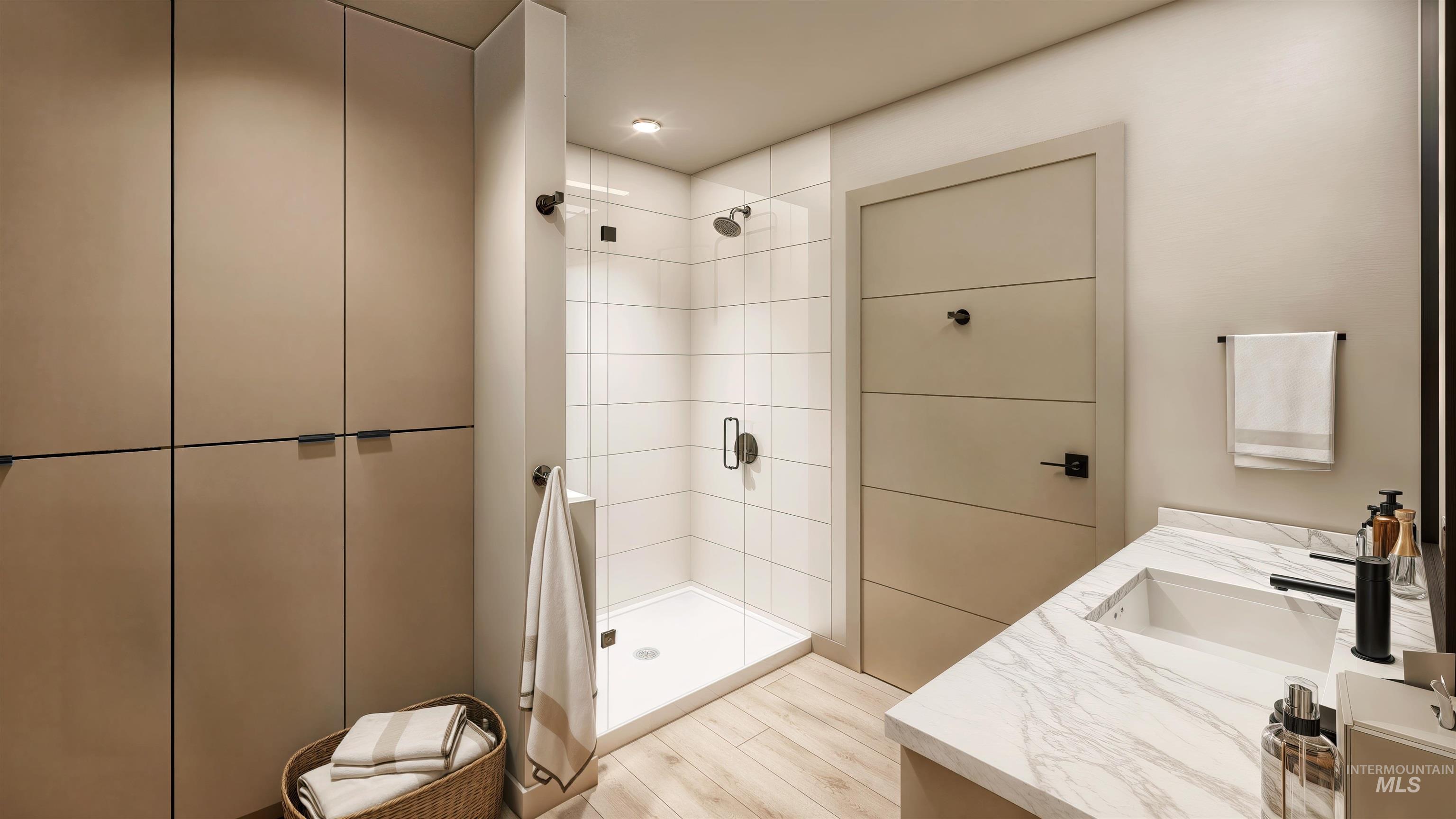 Full bathroom featuring vanity, a shower stall, and light wood-style flooring