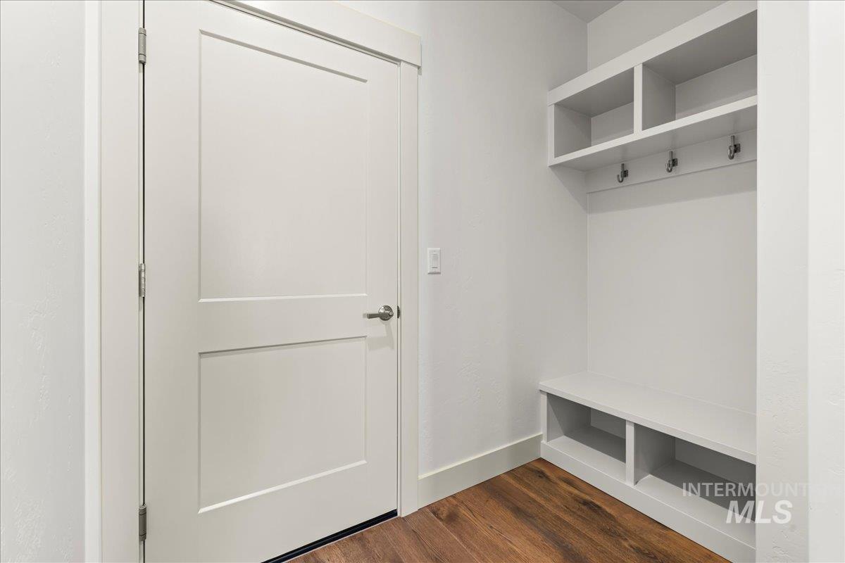 Mudroom featuring dark wood-style flooring and baseboards