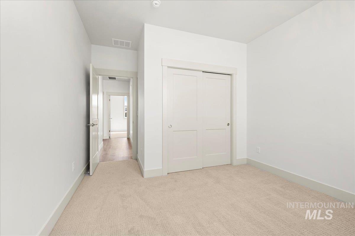 Unfurnished bedroom featuring carpet and a closet