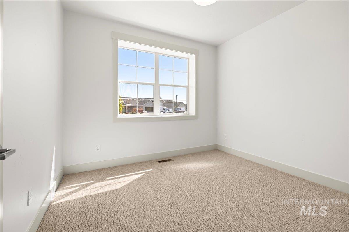 Carpeted empty room with baseboards