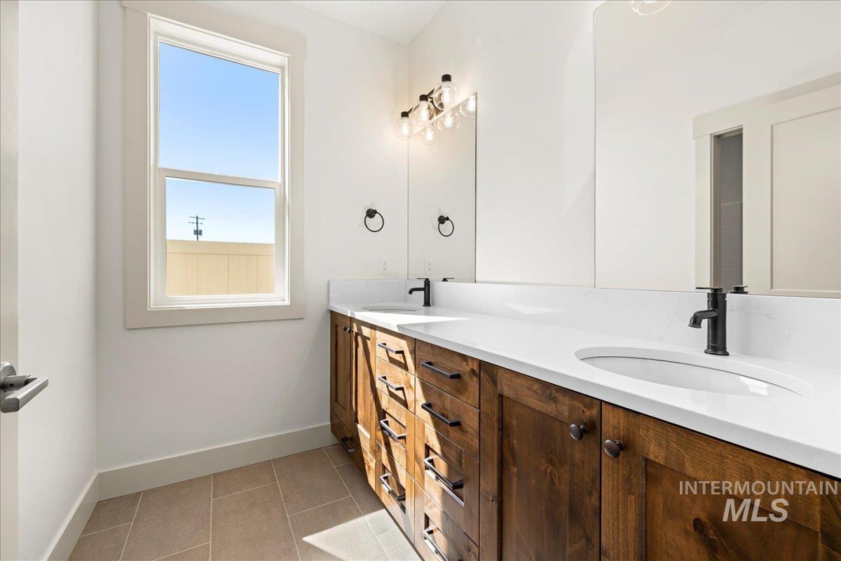 Full bath featuring double vanity and tile patterned floors