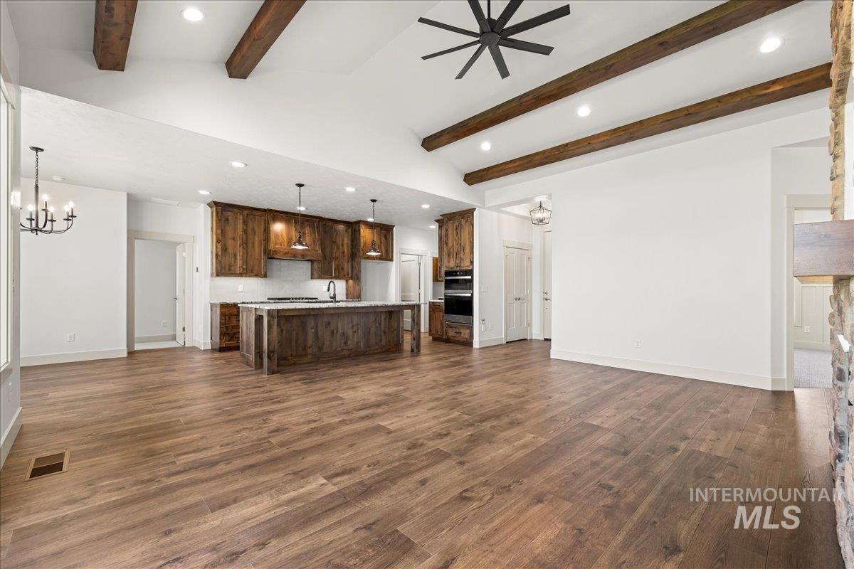 Kitchen with open floor plan, recessed lighting, a chandelier, a center island with sink, and light countertops