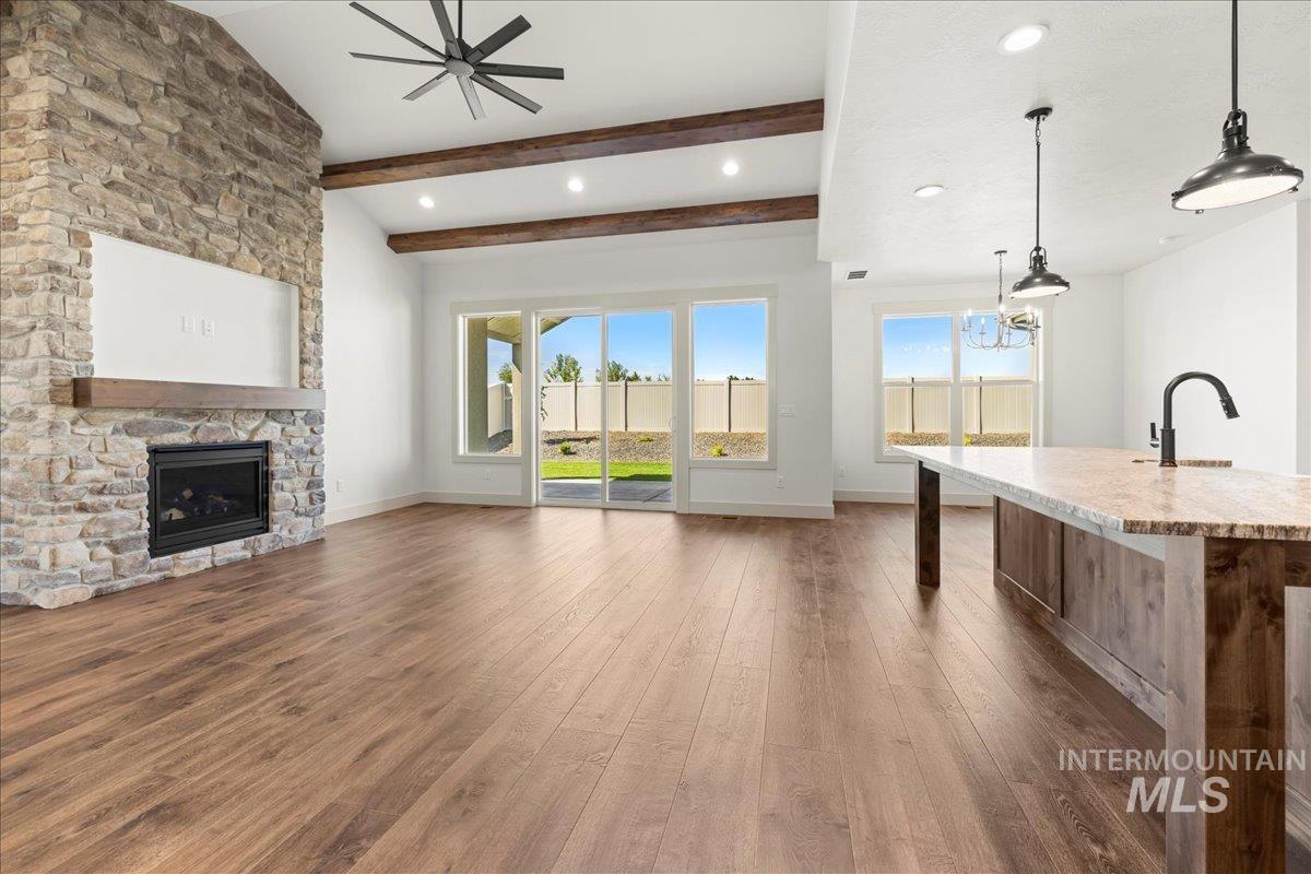 Unfurnished living room featuring hardwood / wood-style floors, plenty of natural light, a fireplace, ceiling fan, and recessed lighting