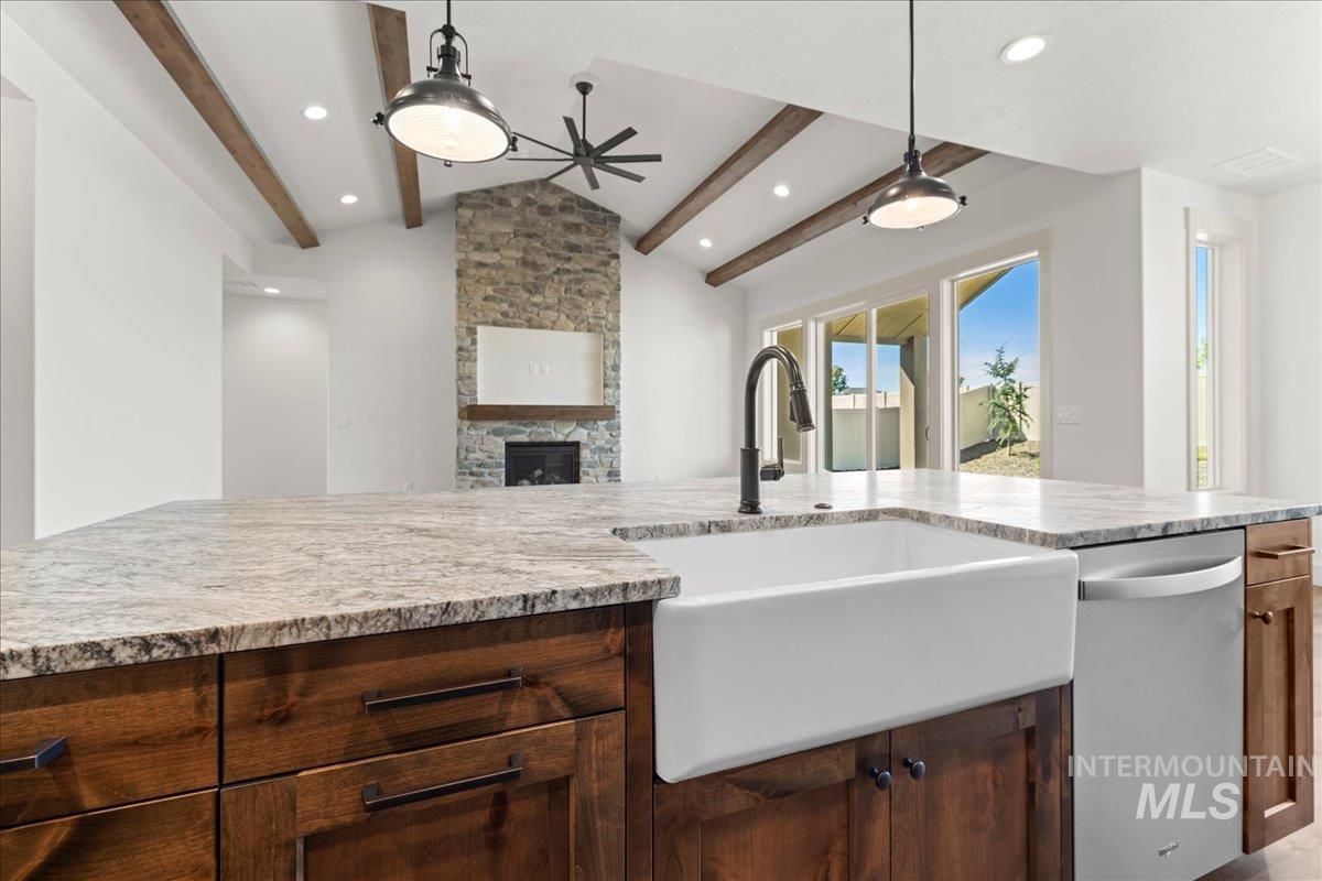 Kitchen with stainless steel dishwasher, a fireplace, decorative light fixtures, open floor plan, and recessed lighting