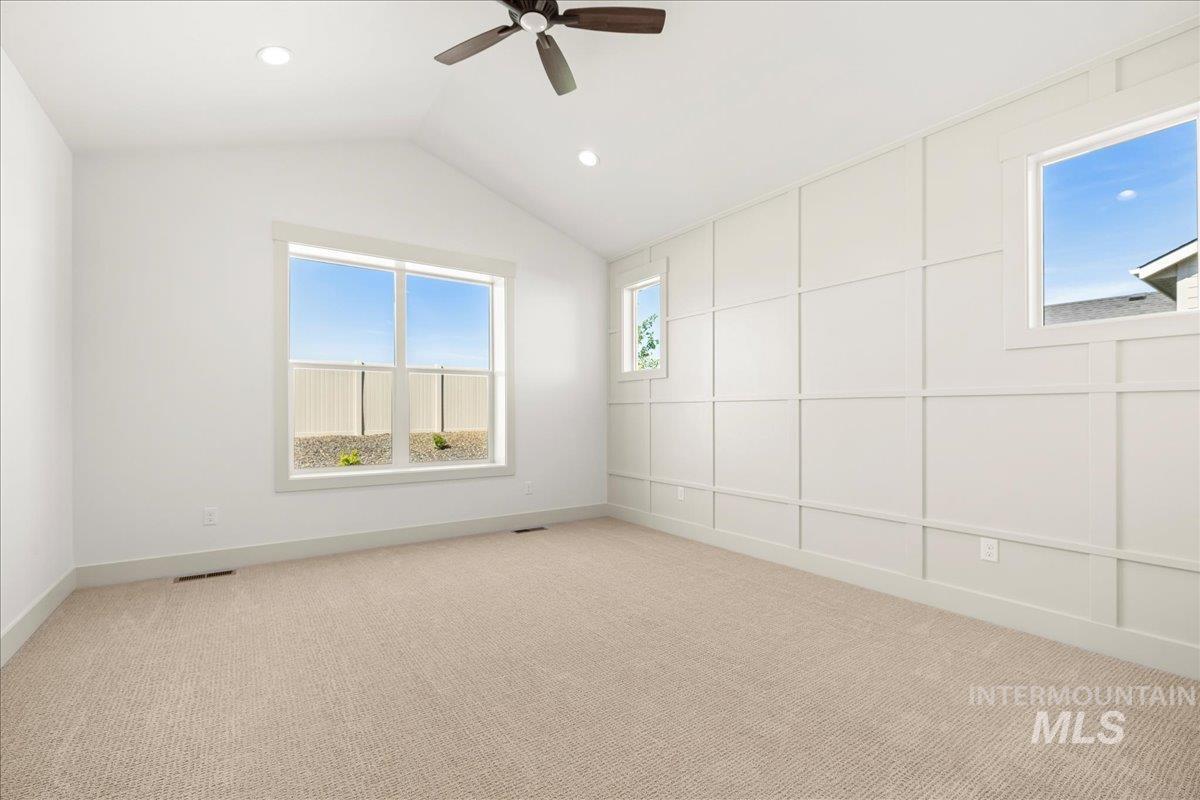 Spare room with light colored carpet, vaulted ceiling, a ceiling fan, and recessed lighting