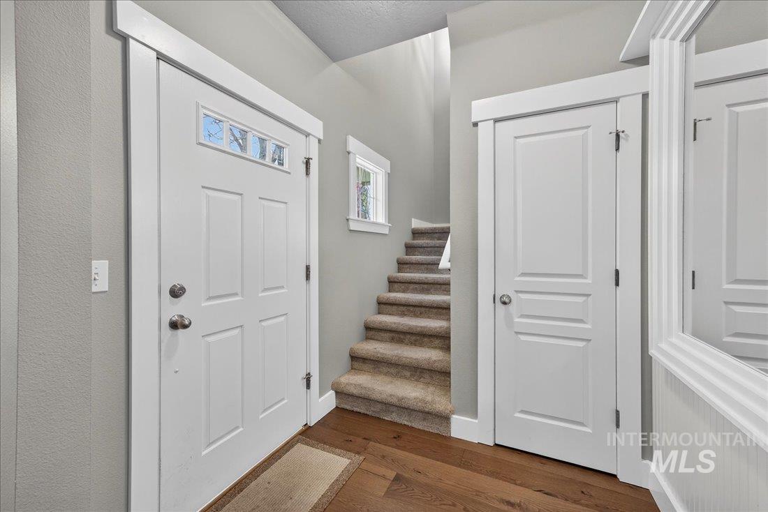 Foyer with dark wood-type flooring and stairway