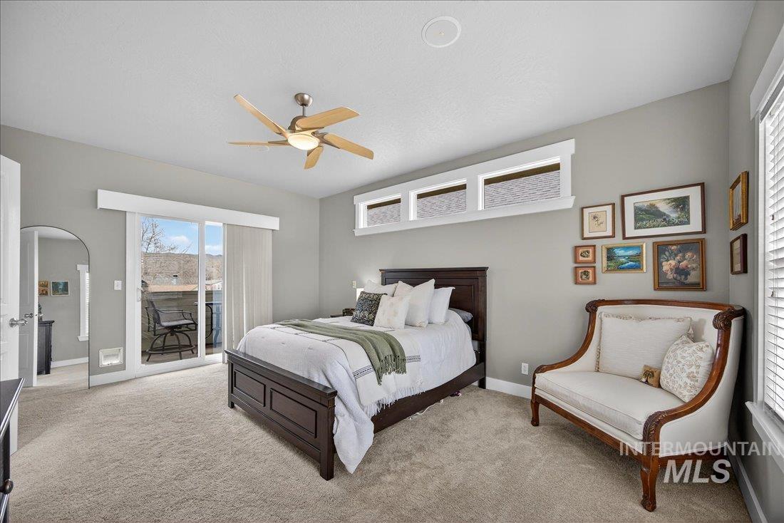 Bedroom with access to outside, carpet flooring, a ceiling fan, and arched walkways