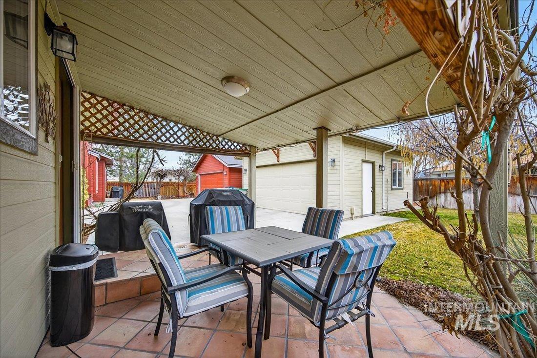 View of patio featuring an outdoor structure, outdoor dining space, and grilling area