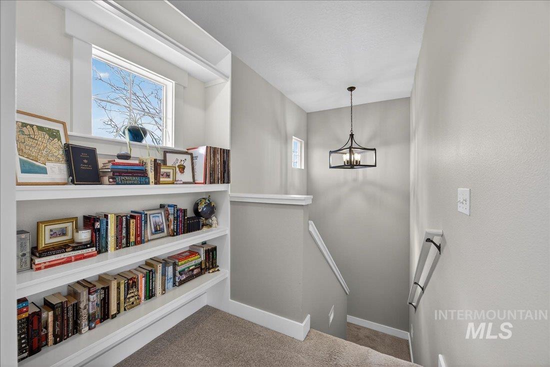 Stairs with carpet and a chandelier