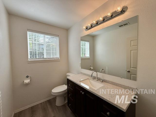 Bathroom featuring a dark wood-finish vanity with a light speckled countertop, under-mount sink, and chrome faucet