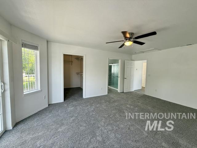 Spacious room featuring gray carpeting, a built-in closet, and a ceiling fan with integrated lighting