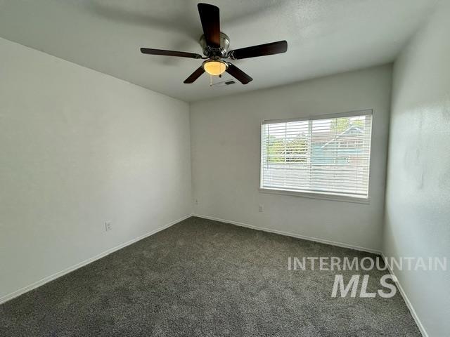 Neutral wall color with a ceiling fan light fixture, window with blinds, and gray carpet