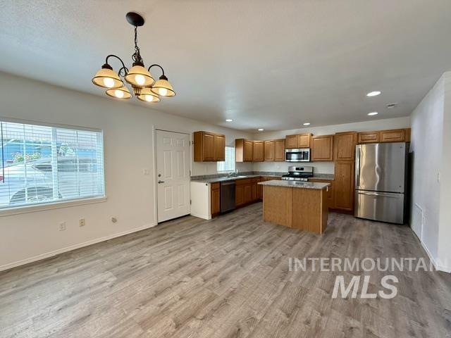 Open-concept kitchen and dining area featuring wood-finish flooring