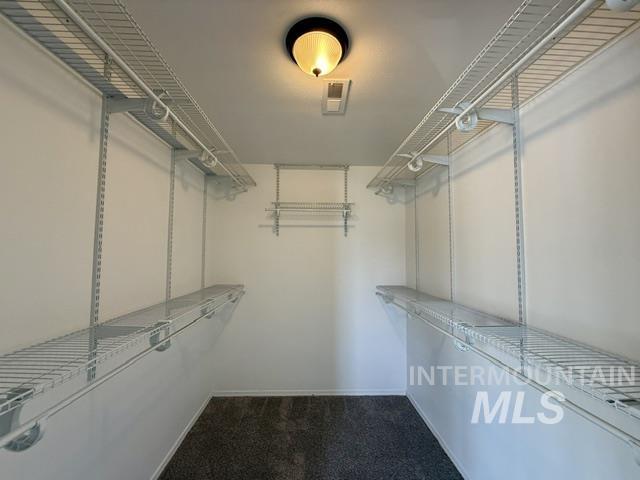 Walk-in closet with wire shelving and hanging rods