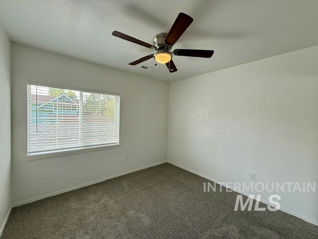 Room featuring a ceiling fan with integrated lighting, a window with blinds, light-toned walls, and a textured gray carpet