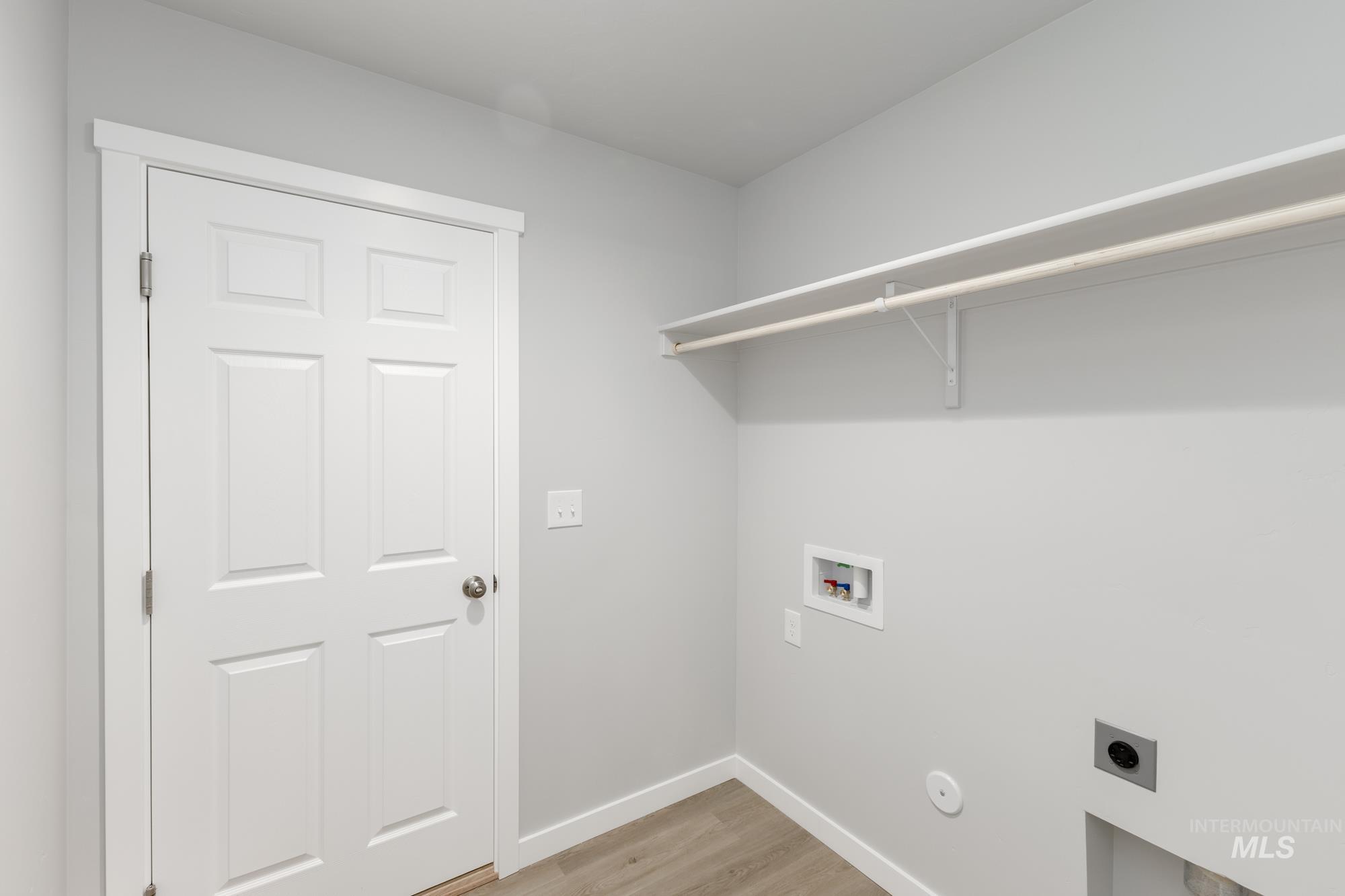 Laundry room featuring light wood finished floors, hookup for an electric dryer, and hookup for a washing machine