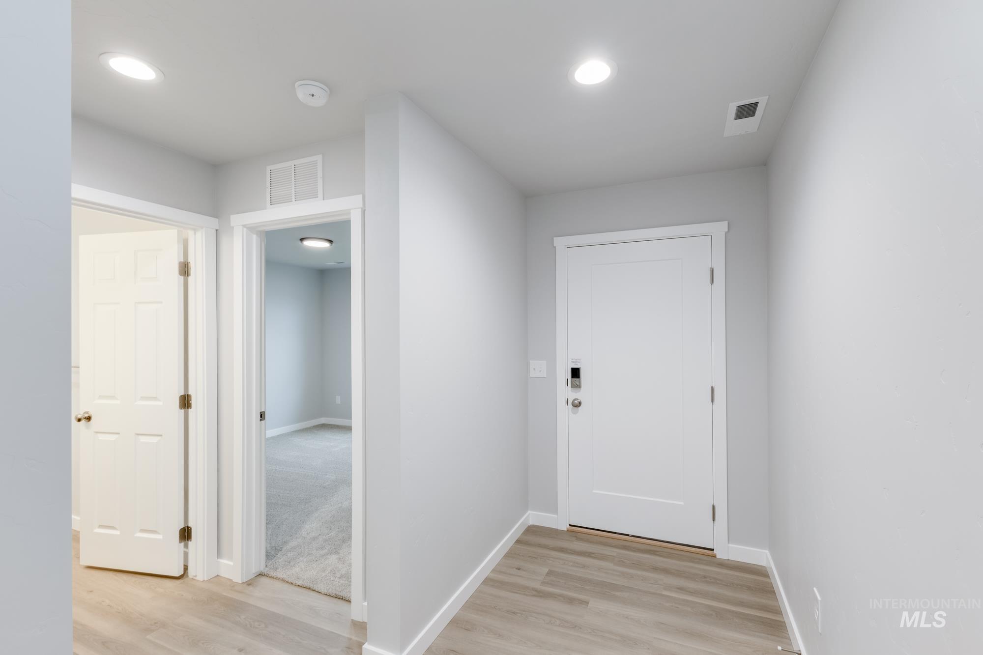 Hall featuring light wood finished floors and recessed lighting