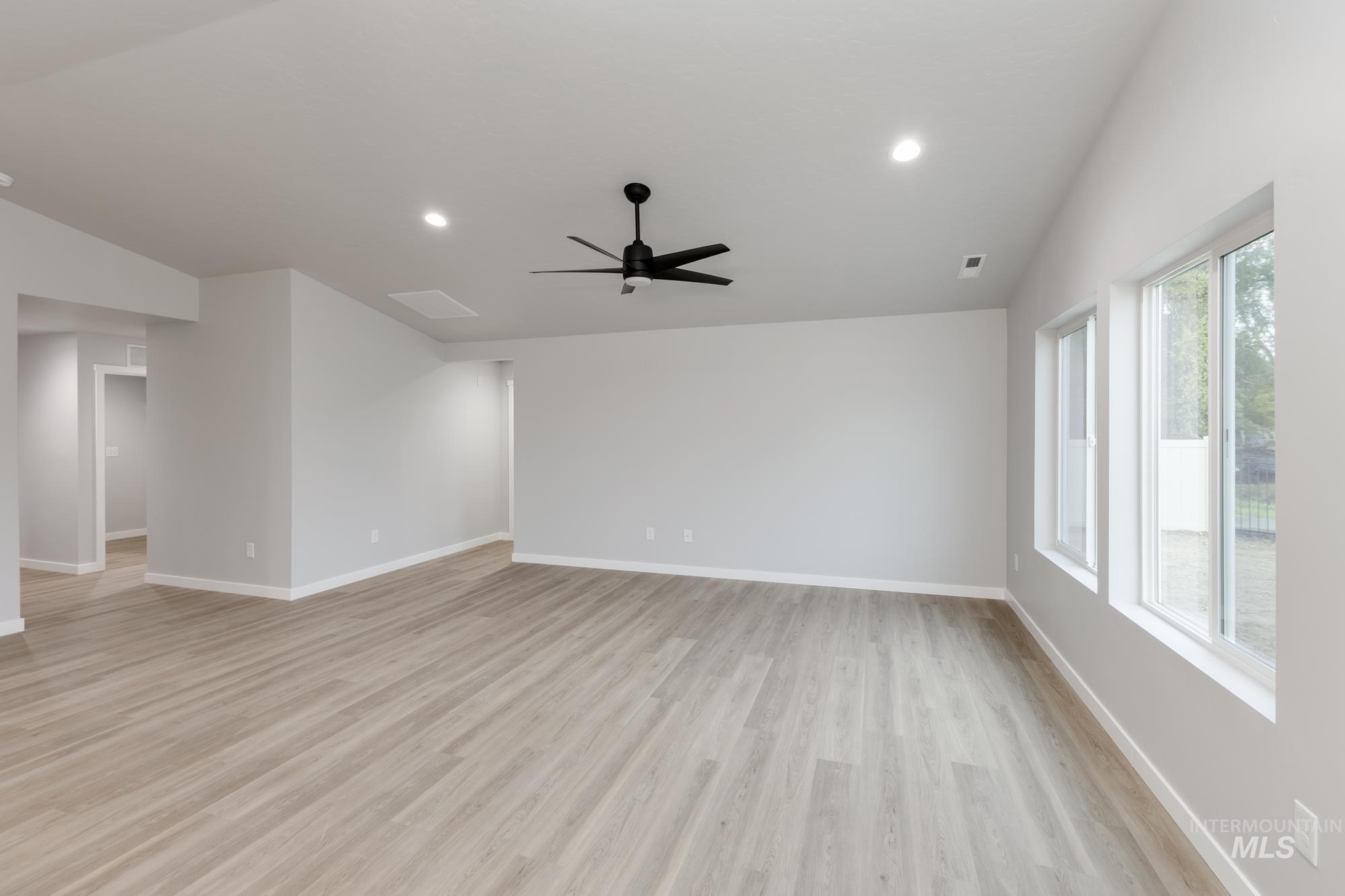 Spare room with lofted ceiling, light wood-style floors, recessed lighting, and a ceiling fan