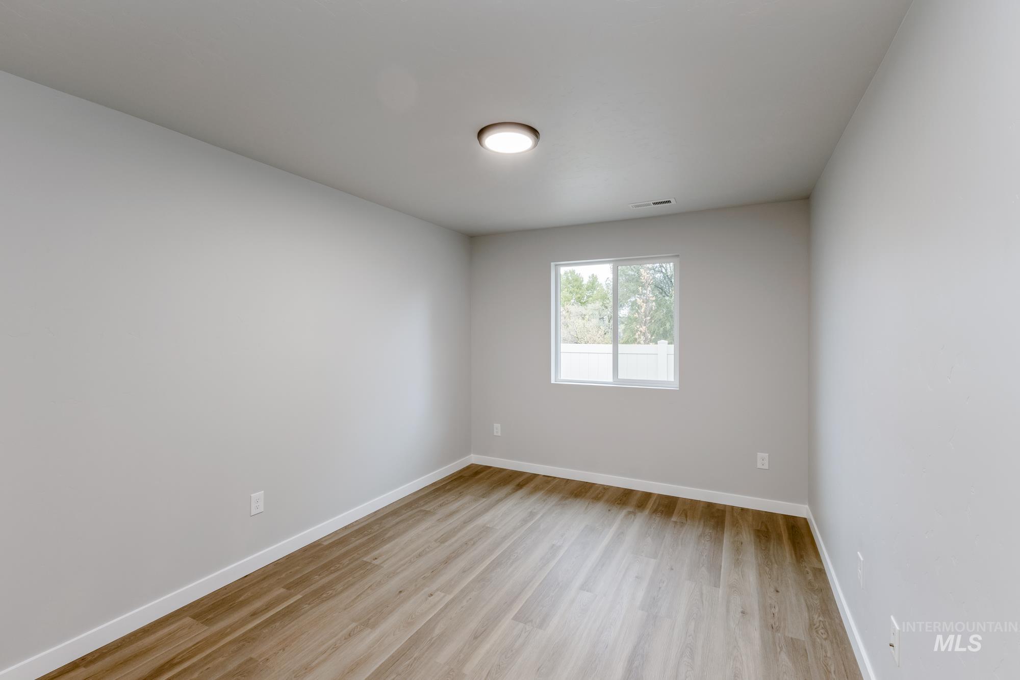 Empty room with baseboards and light wood finished floors