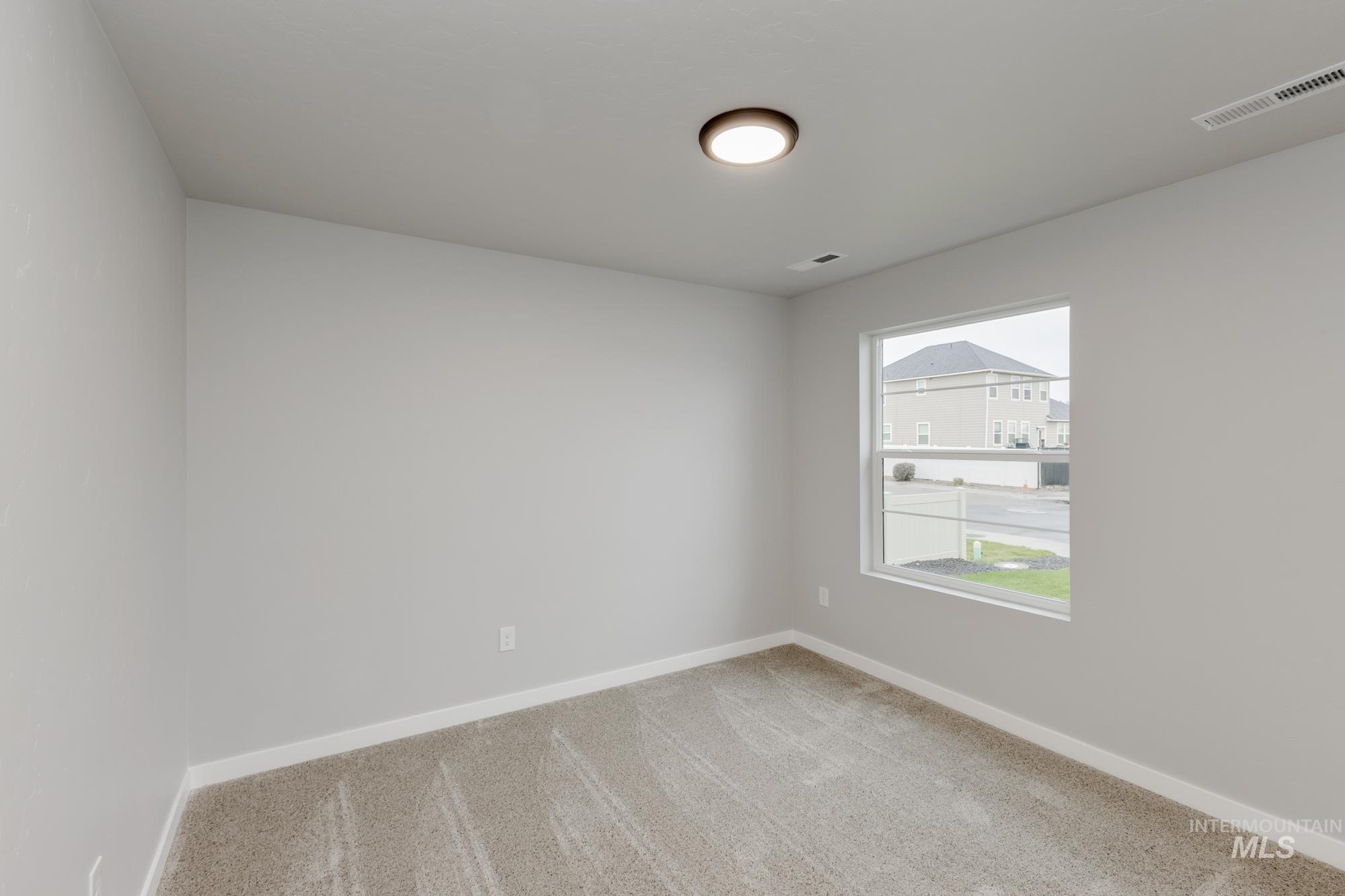 Empty room featuring light carpet and baseboards