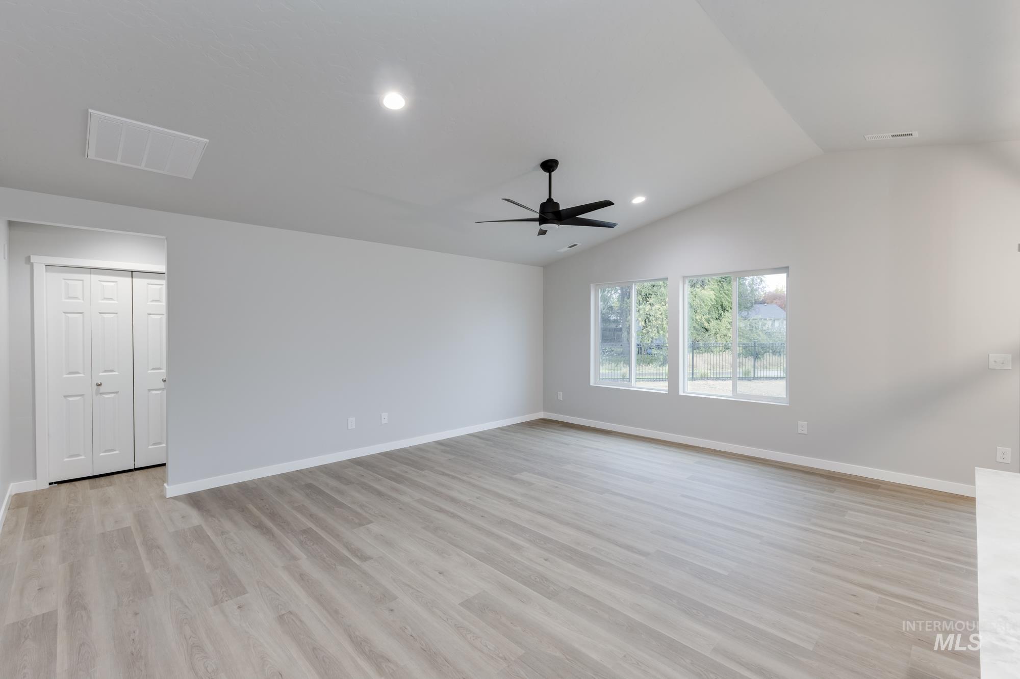 Unfurnished room featuring light wood-style floors, lofted ceiling, recessed lighting, and a ceiling fan