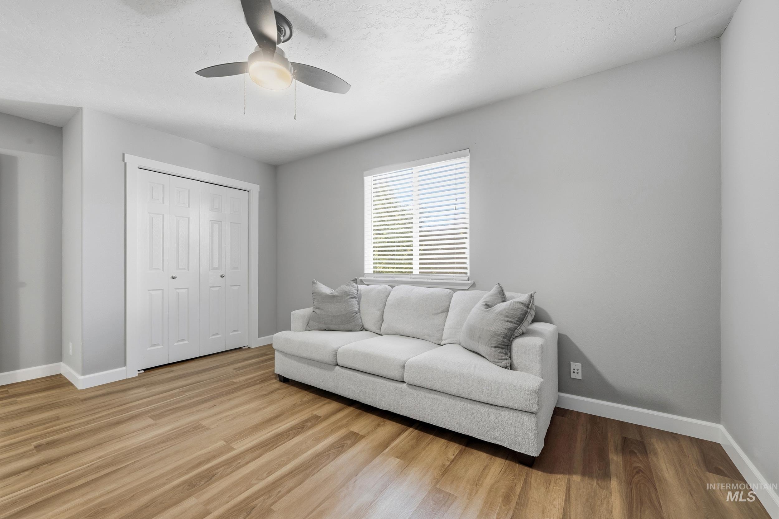 Living room featuring light wood-style flooring and ceiling fan