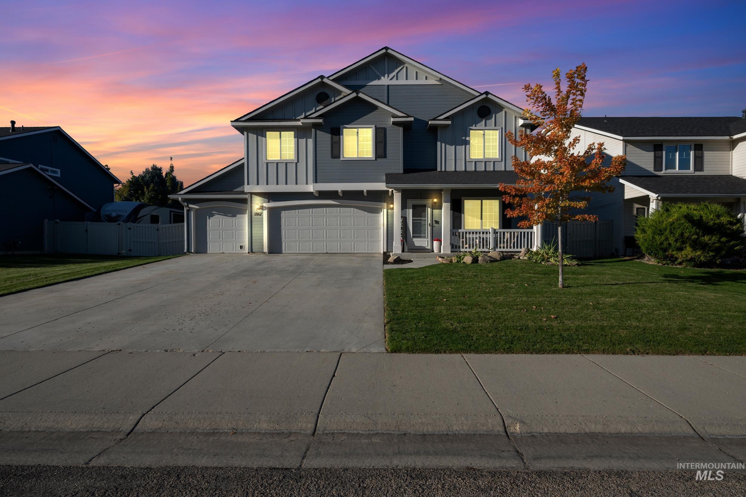 View of front of home featuring board and batten siding, driveway, a garage, and covered porch