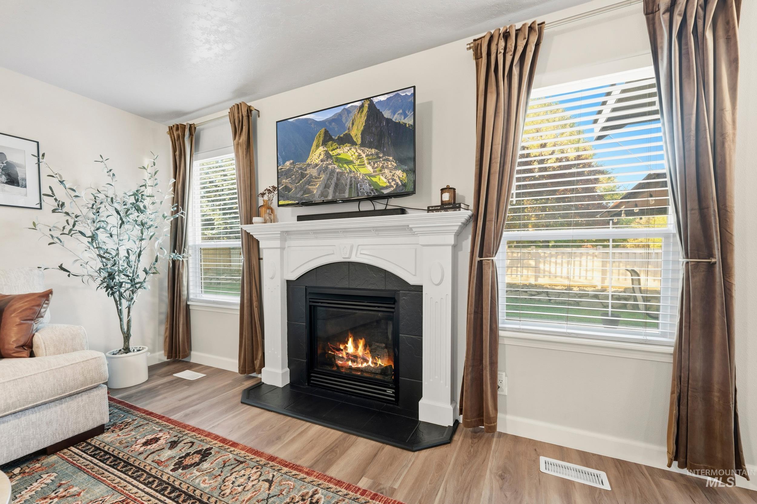 Living area with wood finished floors and a tile fireplace
