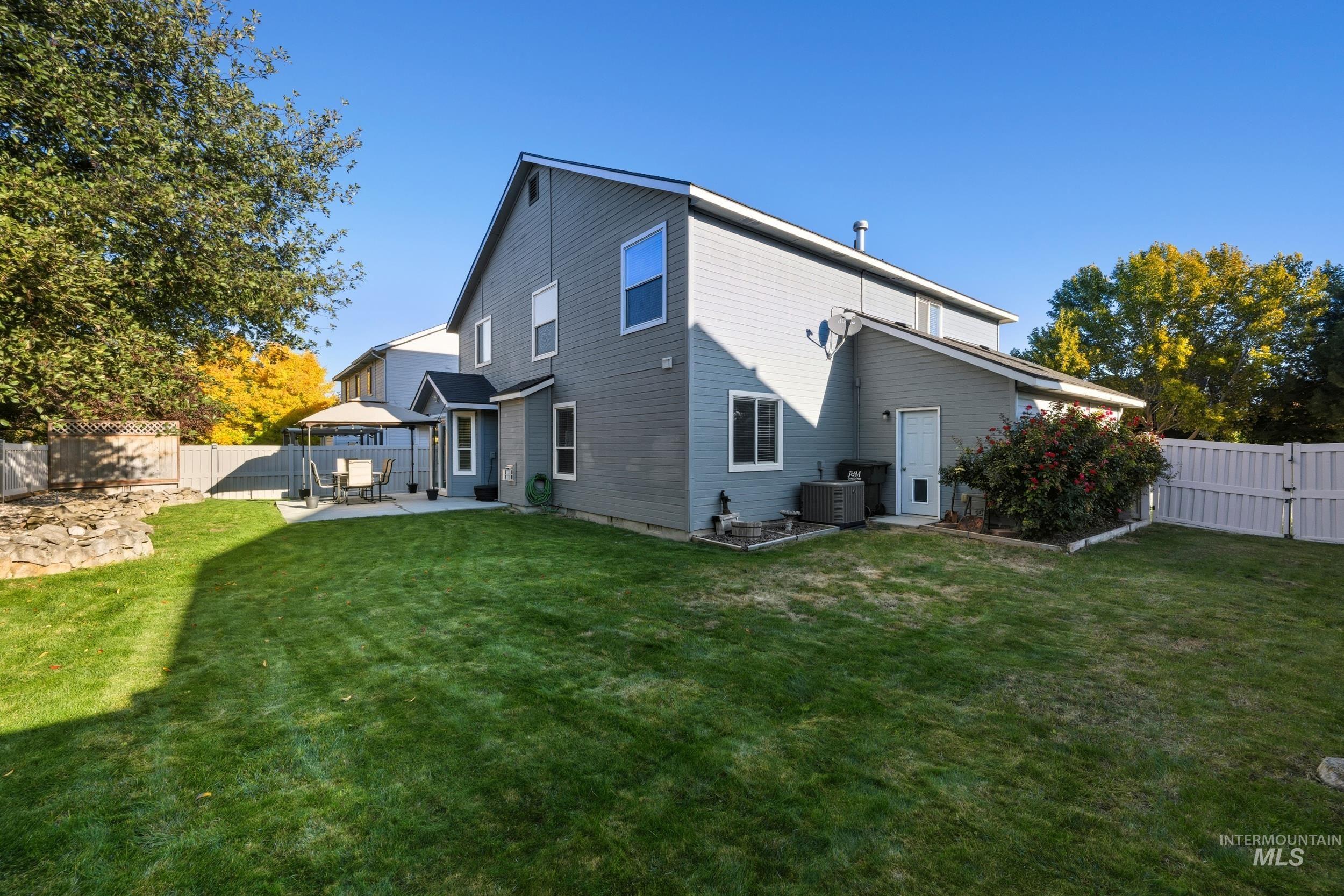 Back of house with a fenced backyard, a gazebo, a patio area, and a gate