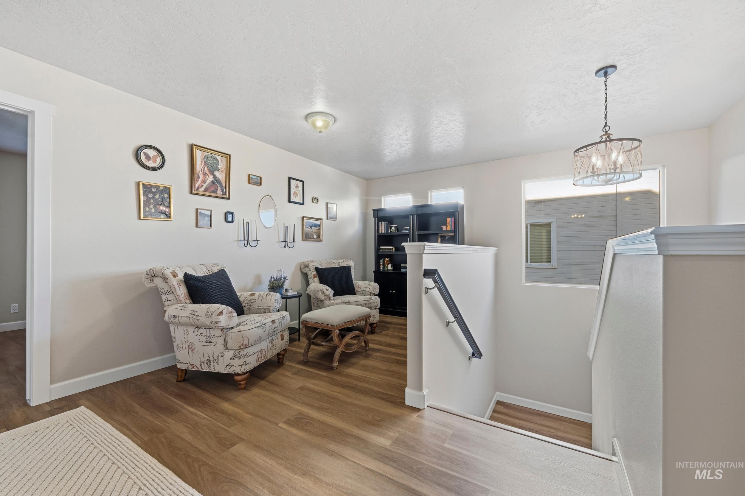 Living area with an upstairs landing and wood finished floors