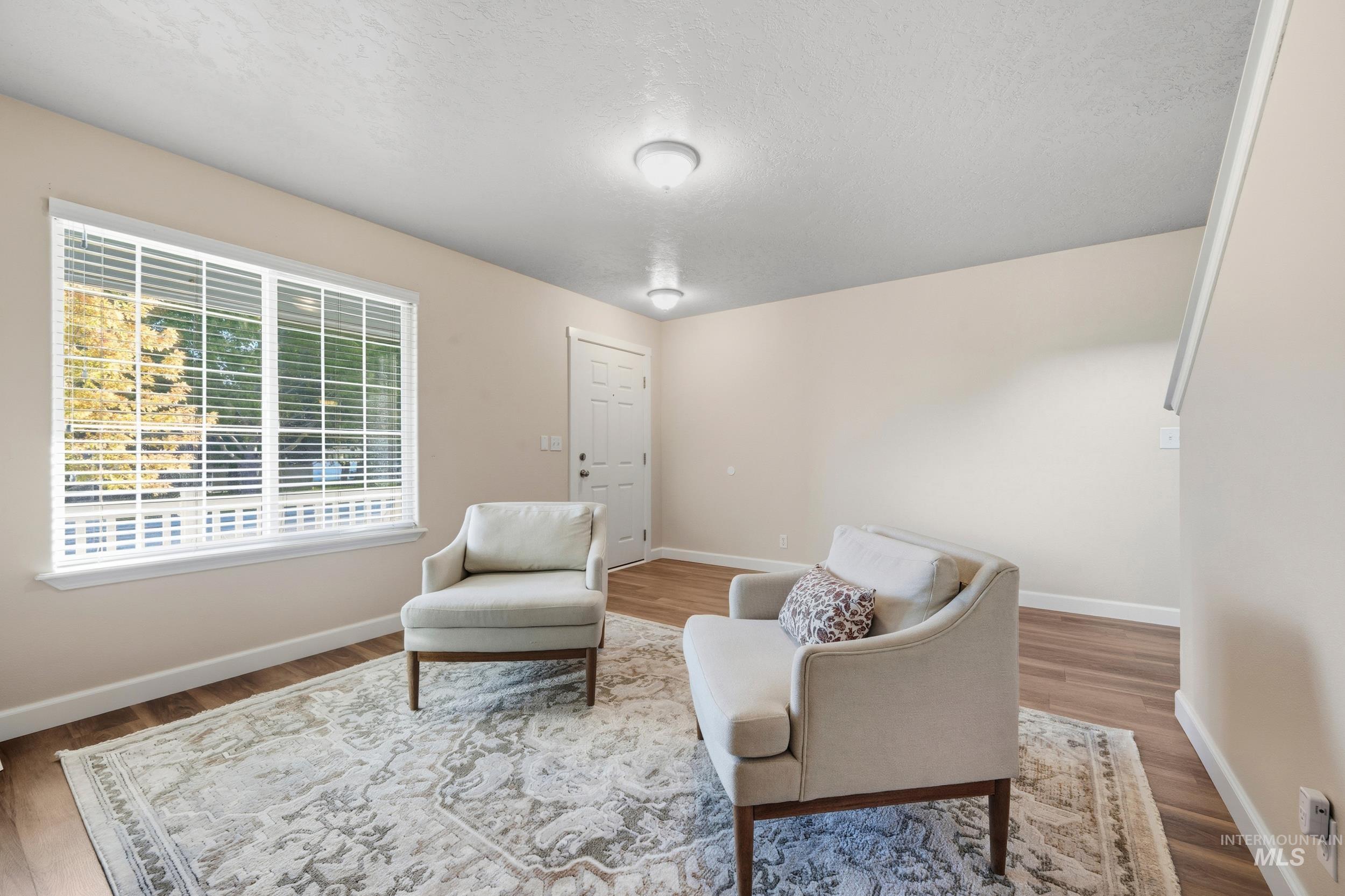 Sitting room featuring a textured ceiling and wood finished floors