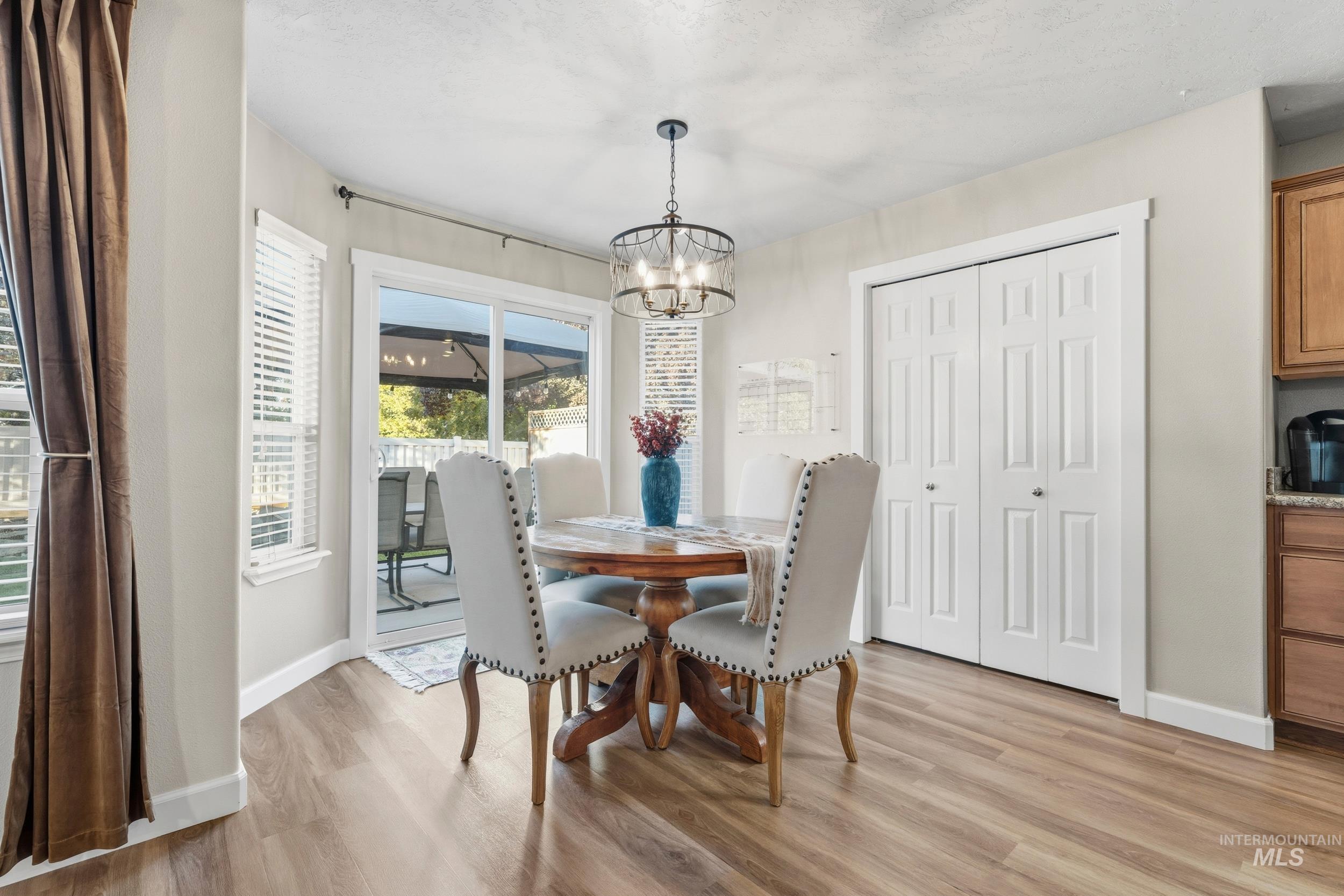 Dining area with light wood-style floors and a chandelier