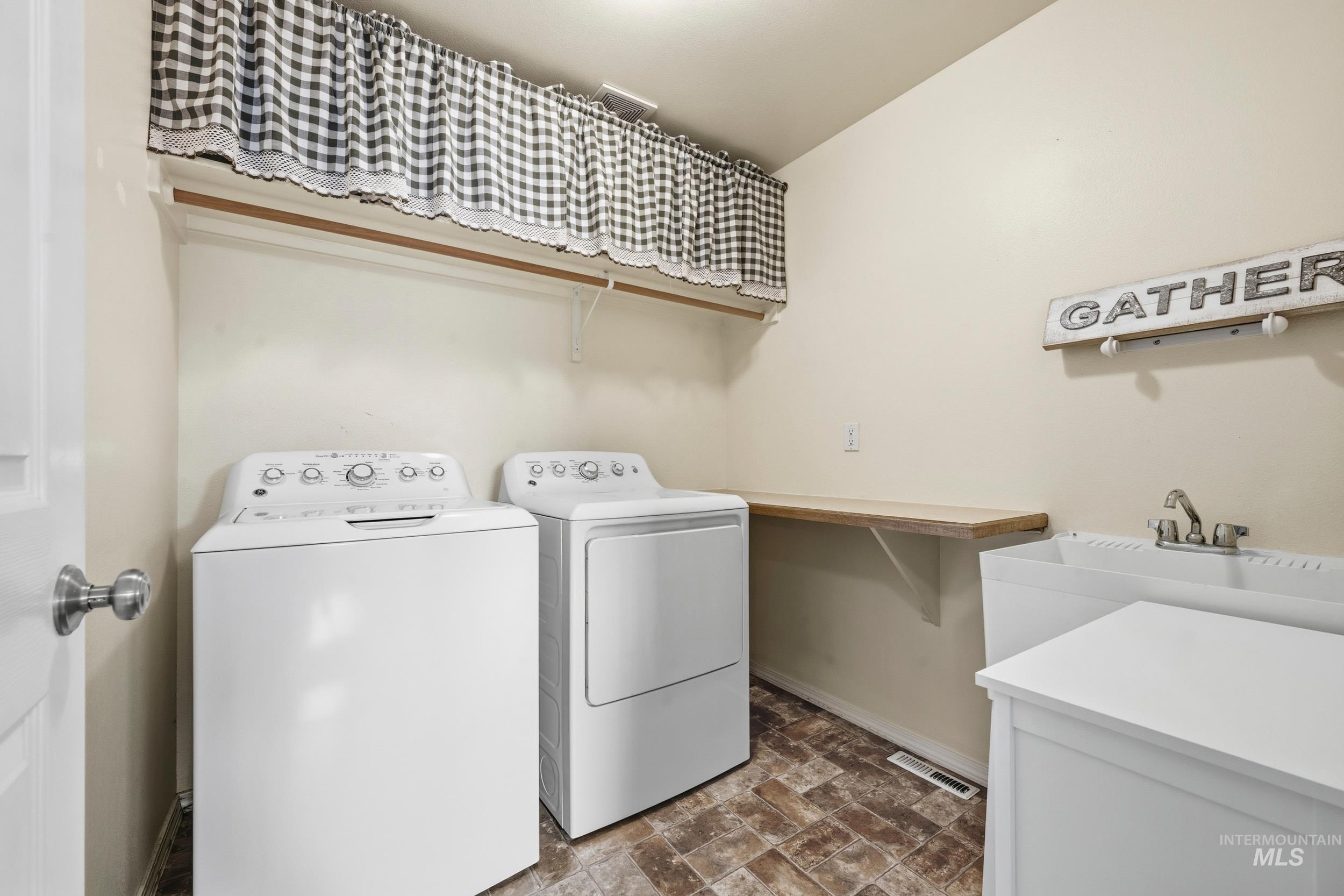 Laundry room featuring washing machine and clothes dryer and baseboards