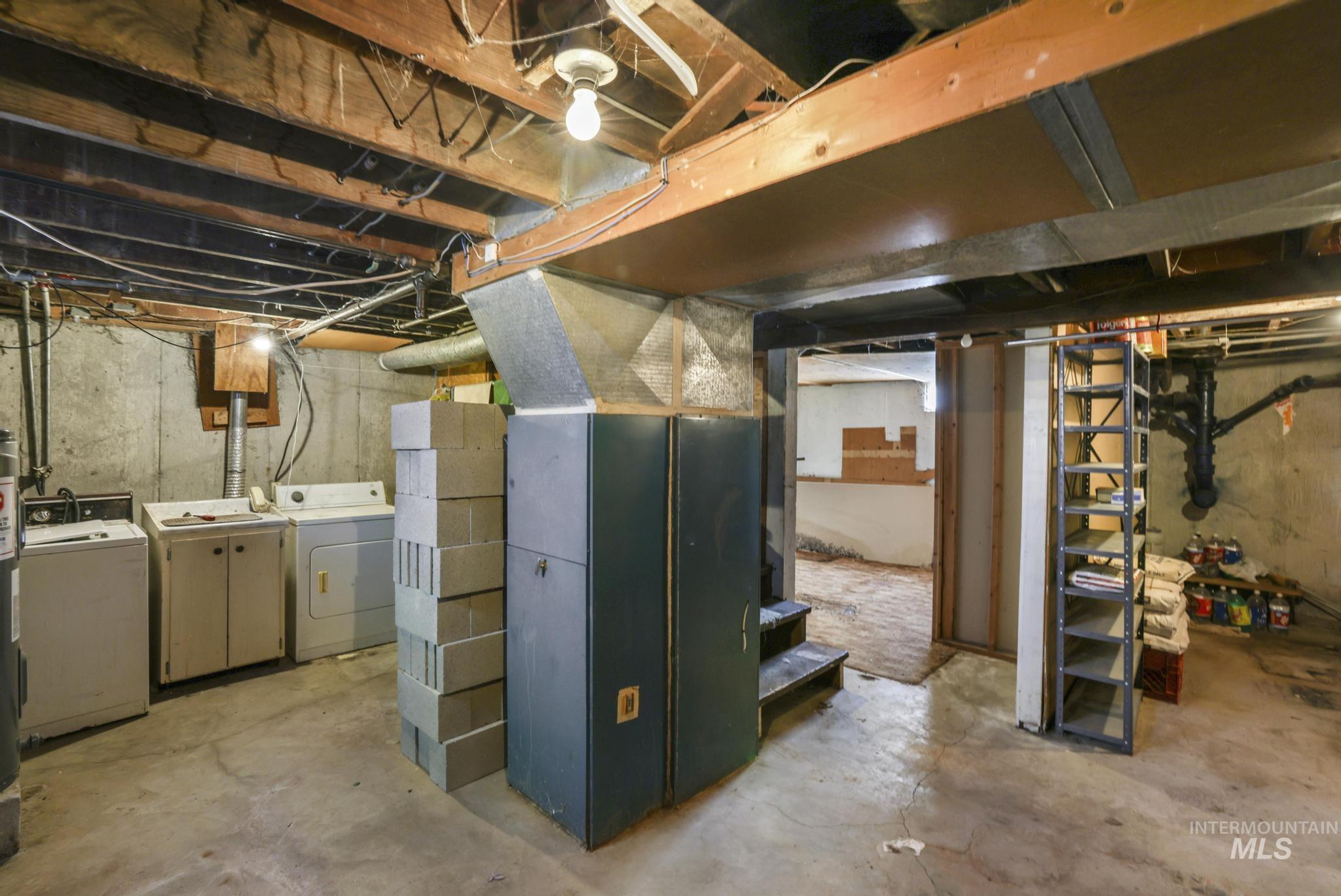 Unfinished below grade area with separate washer and dryer, heating unit, and stairway