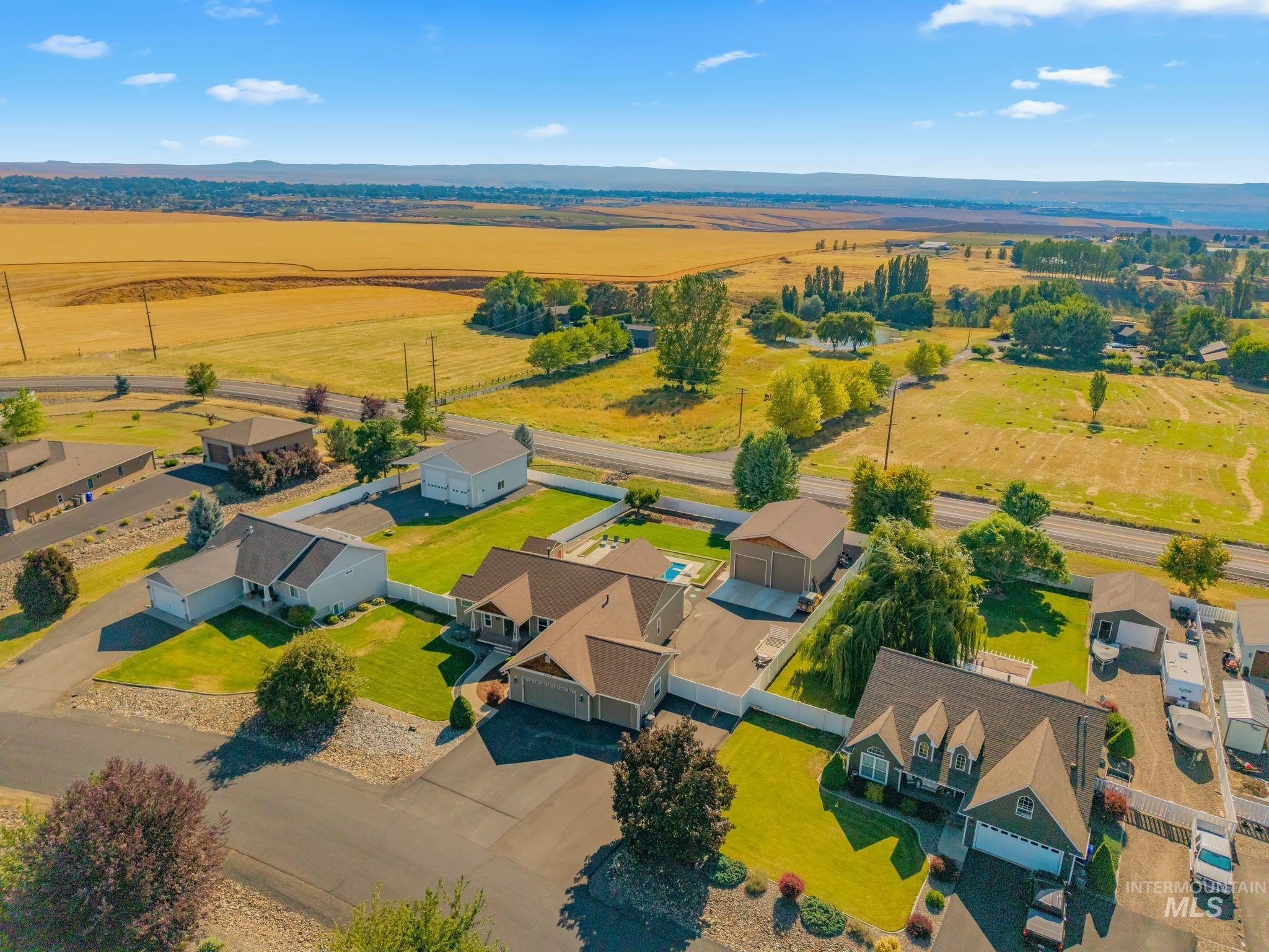 Aerial perspective showcasing multiple properties with expansive golden fields in the background
