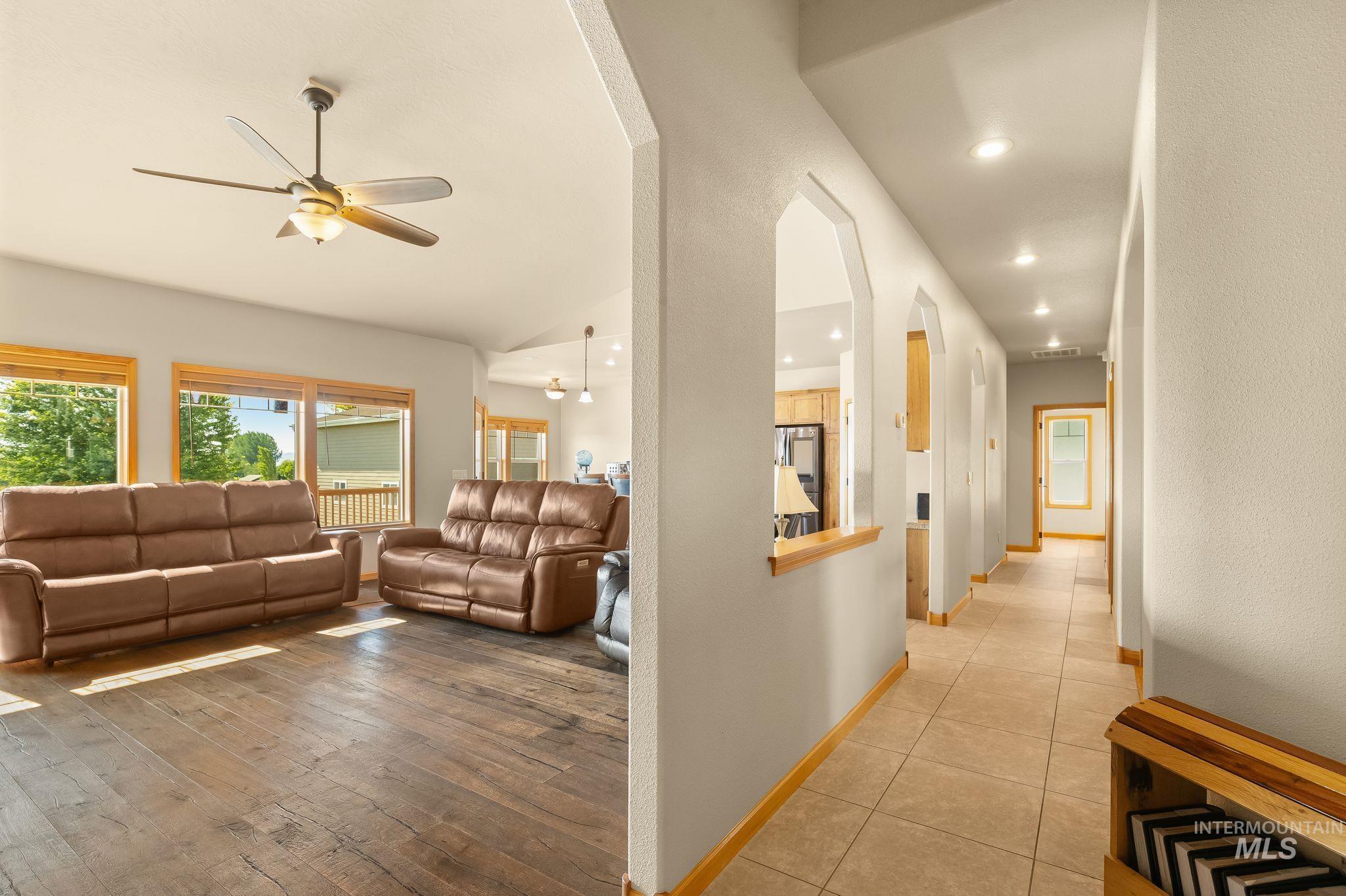 Open living area featuring wood-finish flooring and a ceiling fan