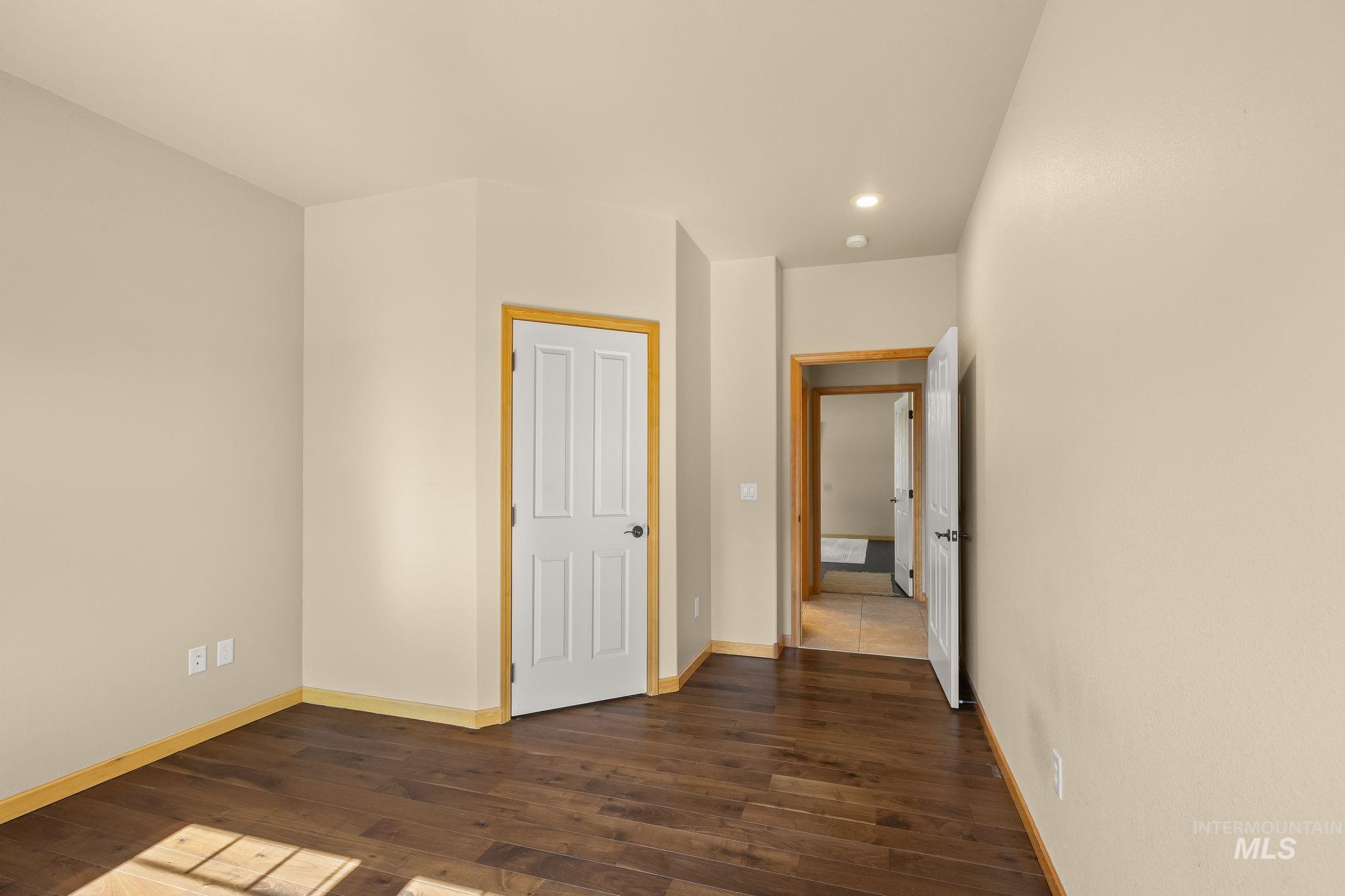 Interior room featuring wood-finish flooring, light-toned walls, and recessed lighting